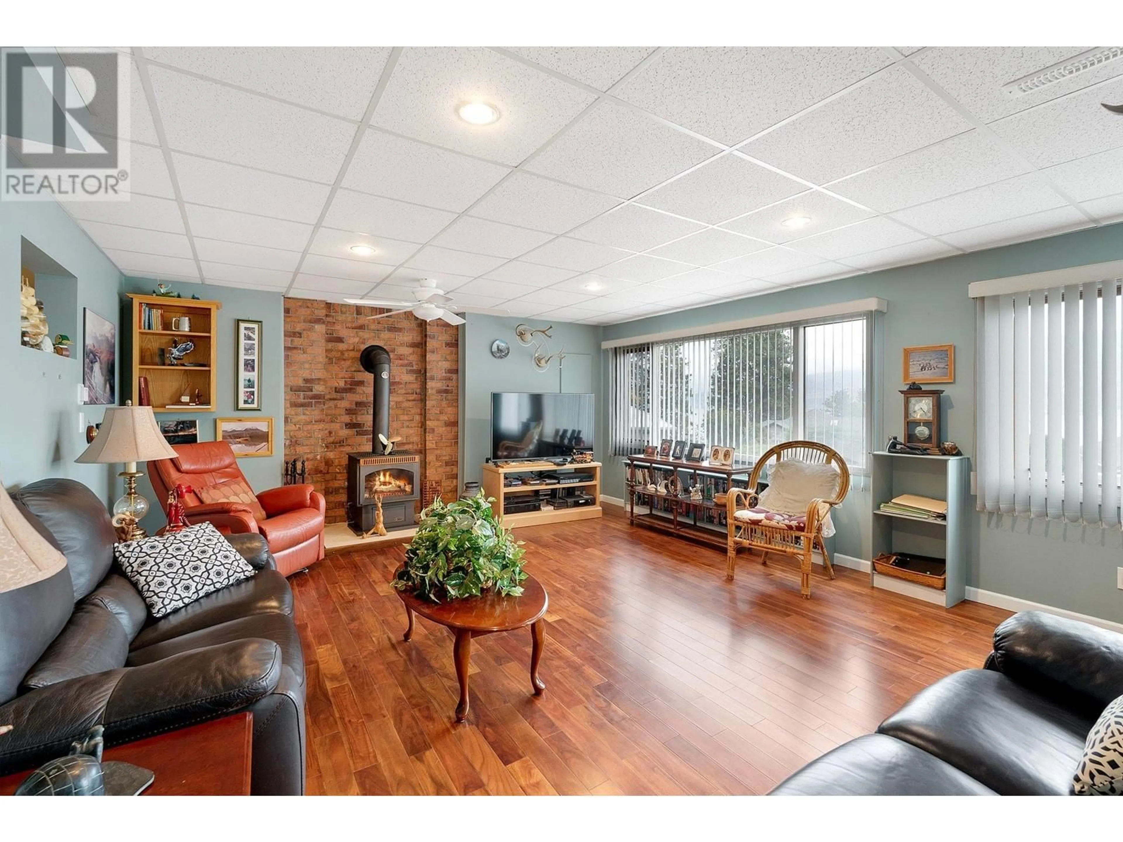 Living room with furniture, wood/laminate floor for 6514 FERGUSON PLACE, Peachland British Columbia V0H1X7