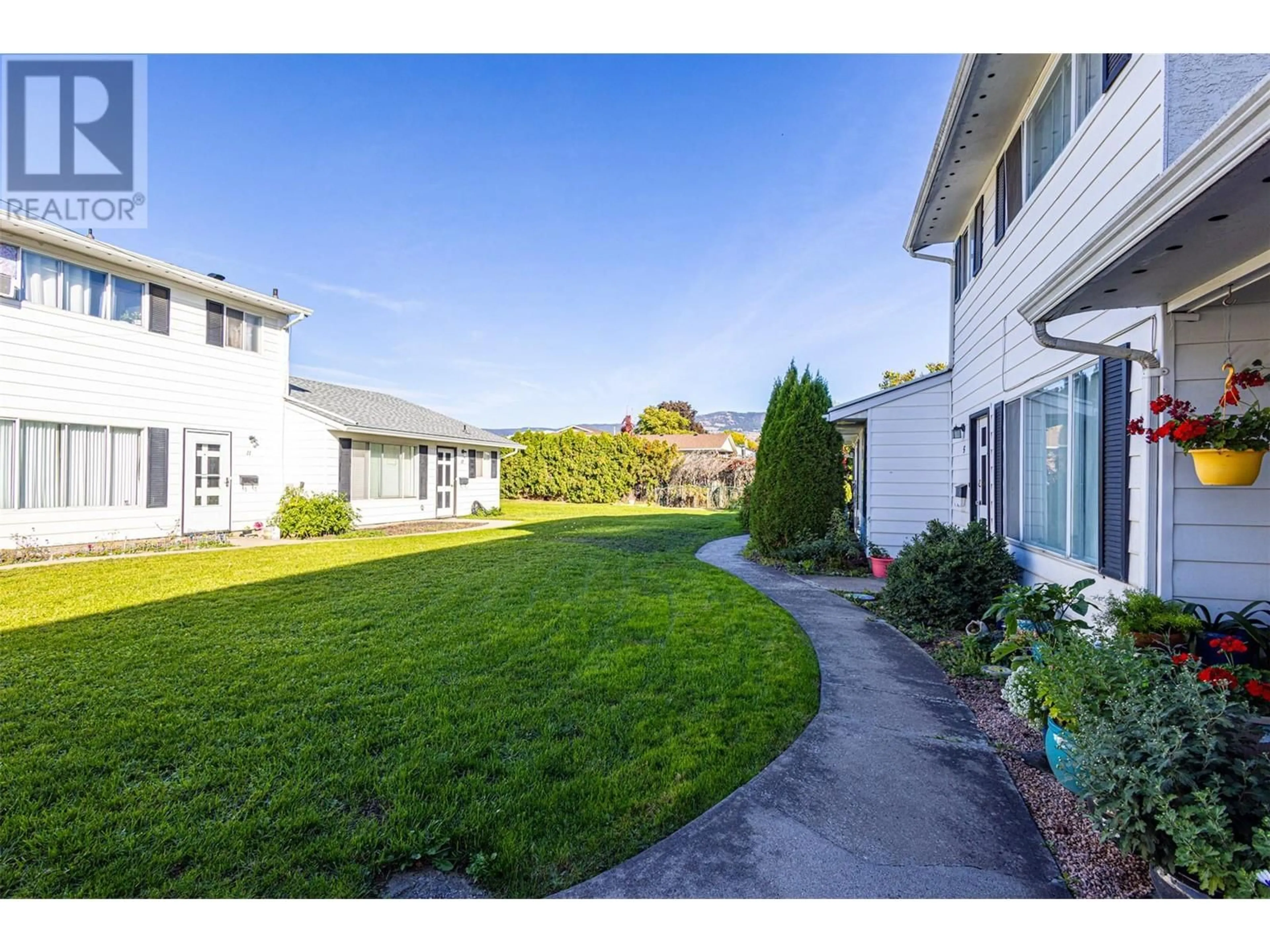 Frontside or backside of a home, the fenced backyard for 185 Taylor Road Unit# 4, Kelowna British Columbia V1X4G1