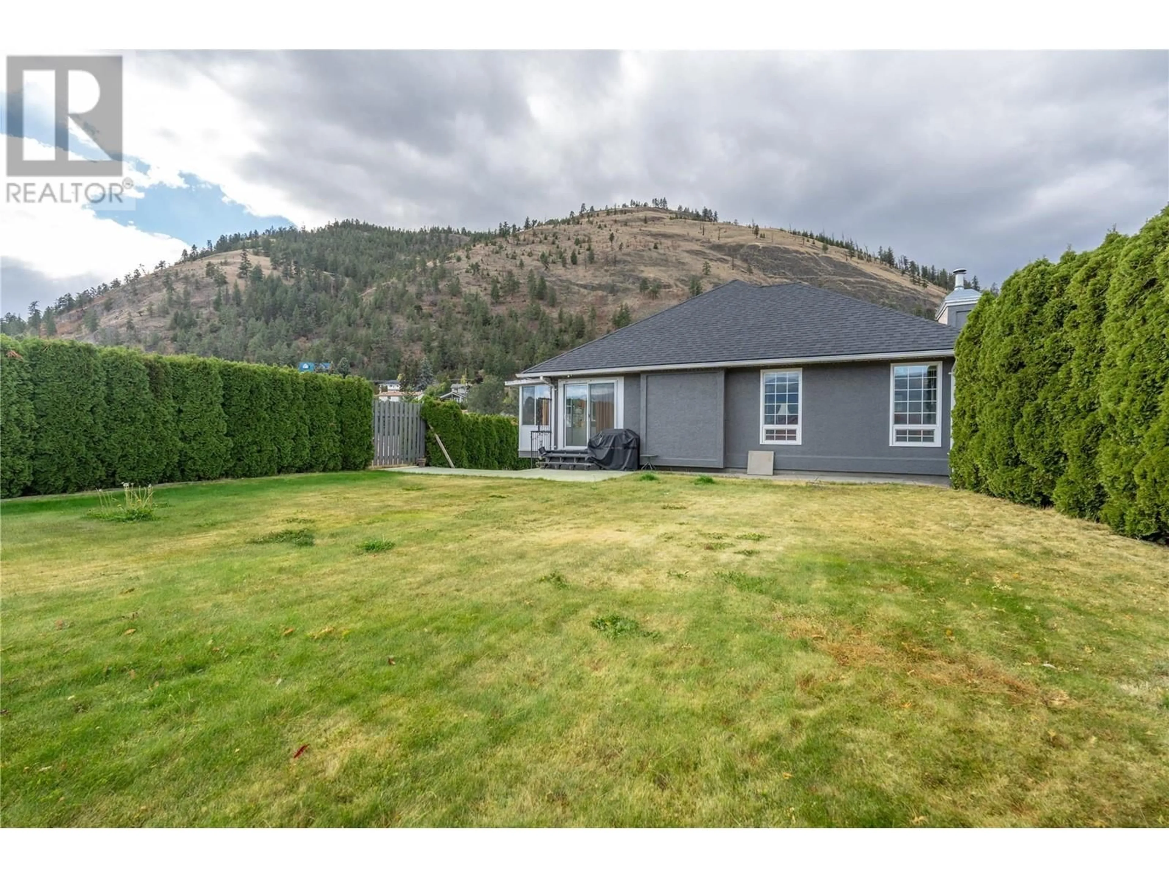 Frontside or backside of a home, the fenced backyard for 6401 Harrison Heights, Summerland British Columbia V0H1Z7