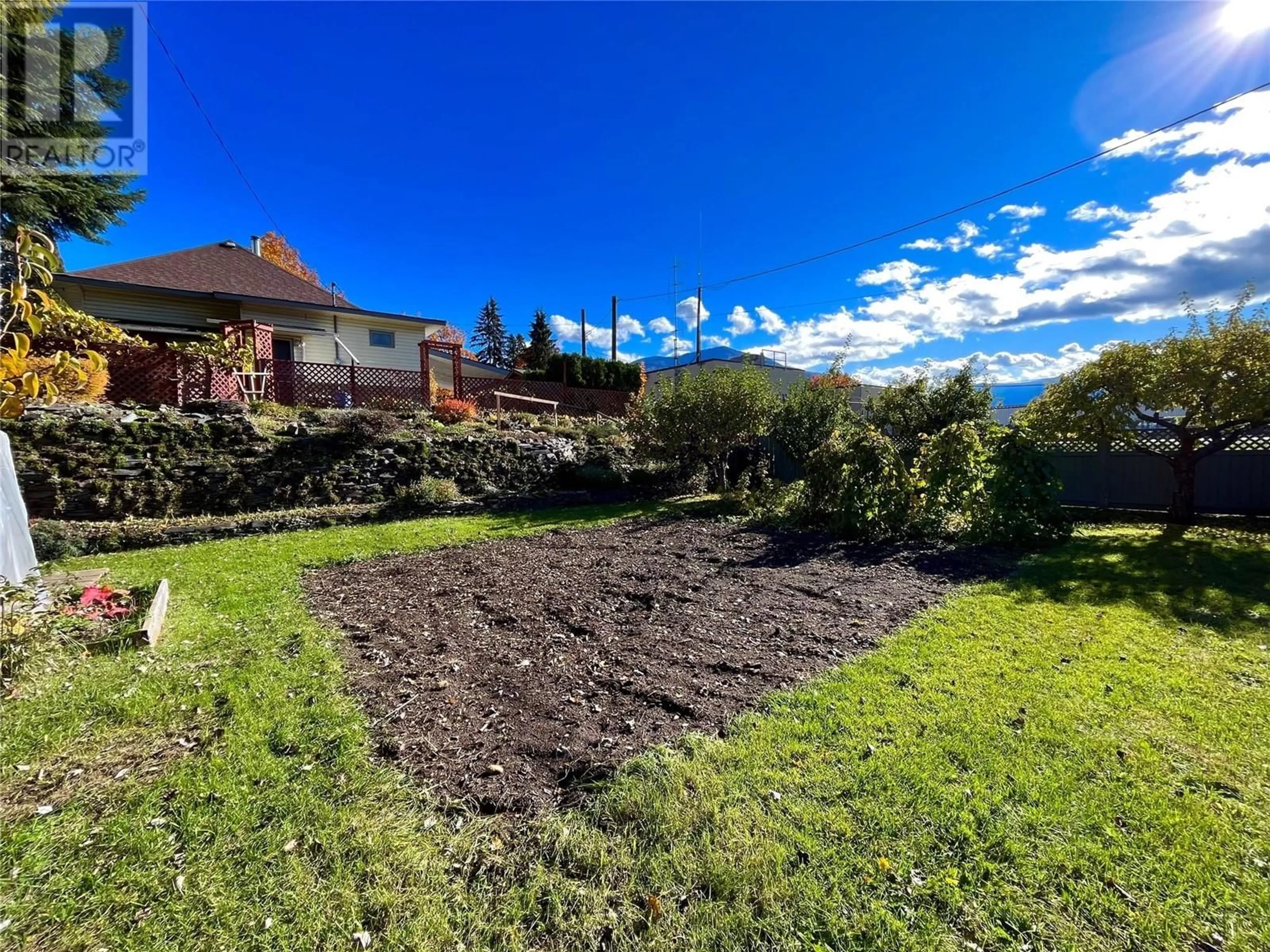 Frontside or backside of a home, the fenced backyard for 108 3rd Avenue NW, Nakusp British Columbia V0G1R0