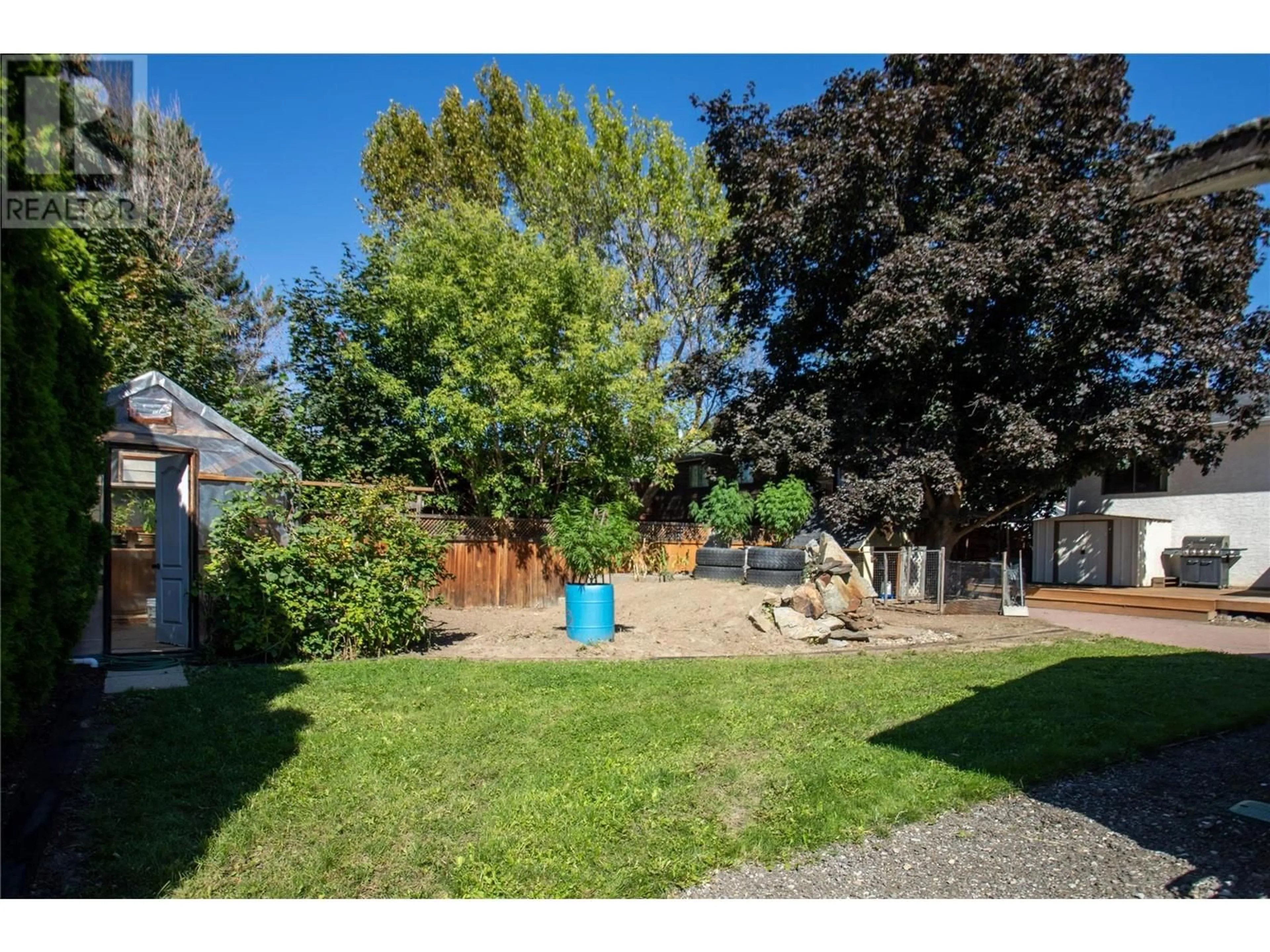 Frontside or backside of a home, the fenced backyard for 2140 Hadden Court, Kelowna British Columbia V1P1G8