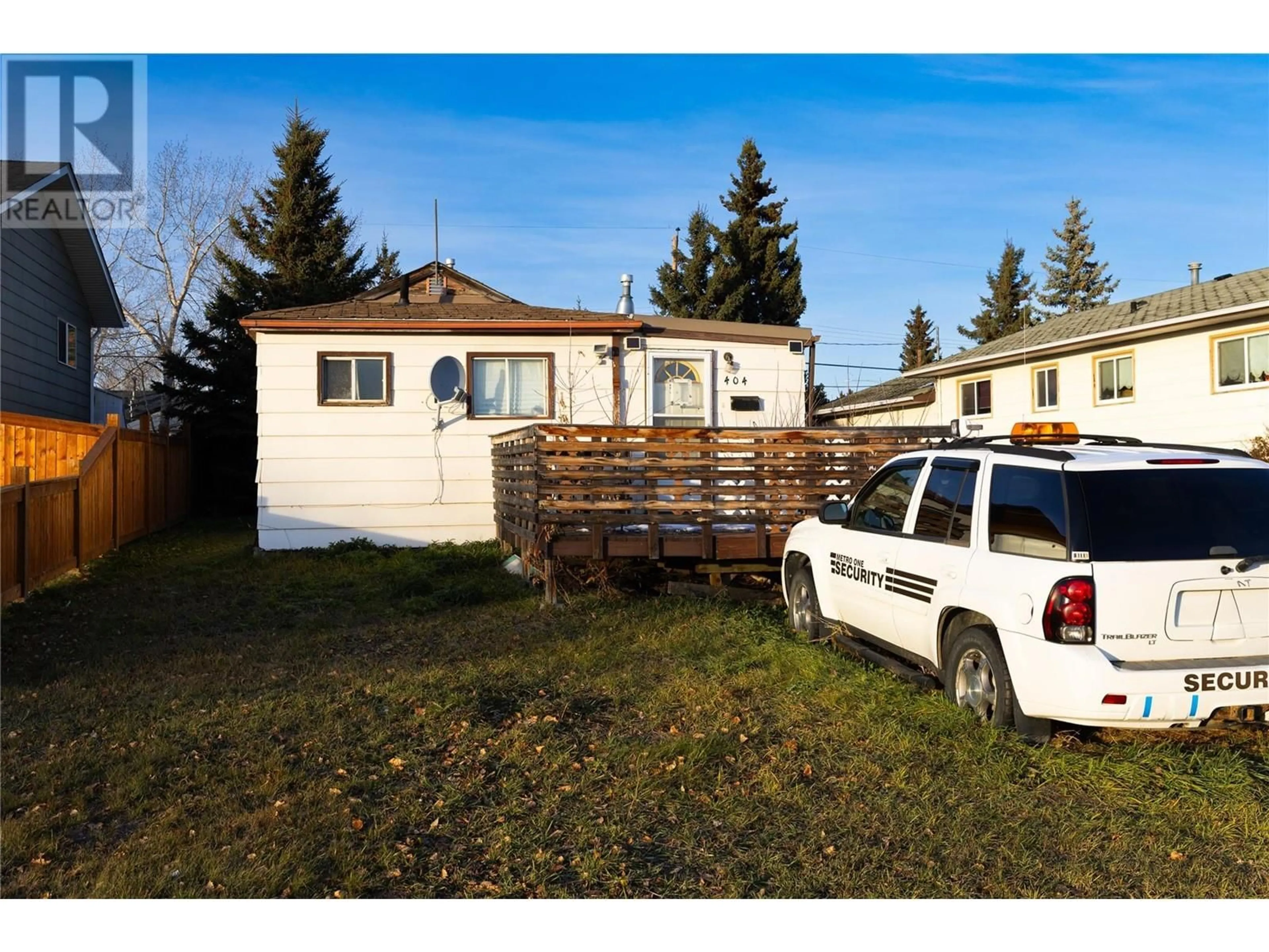 Frontside or backside of a home, the fenced backyard for 404 99 Avenue, Dawson Creek British Columbia V1G1T3