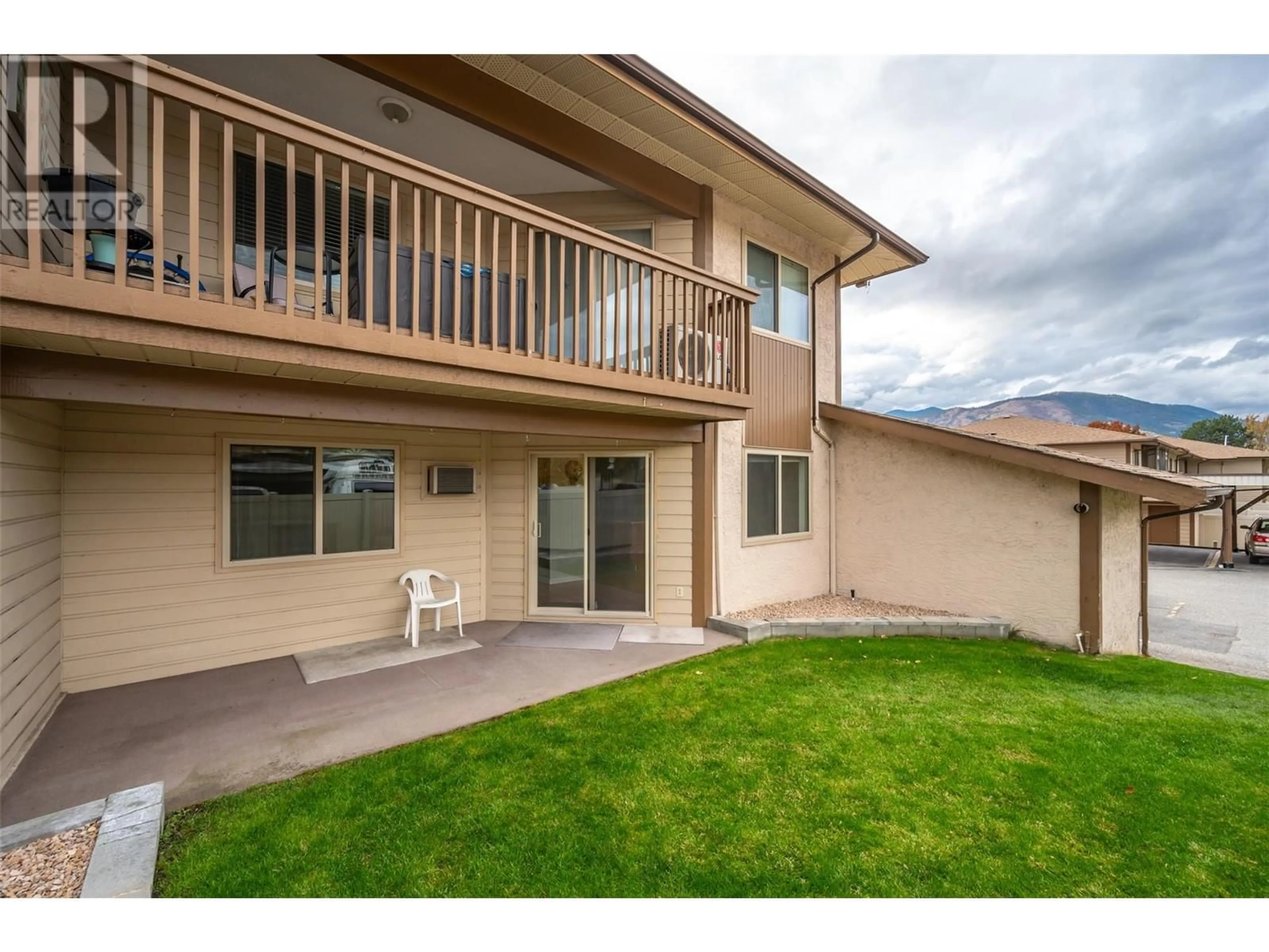 A pic from exterior of the house or condo, the fenced backyard for 1860 Atkinson Street Unit# 106, Penticton British Columbia V2A7M6