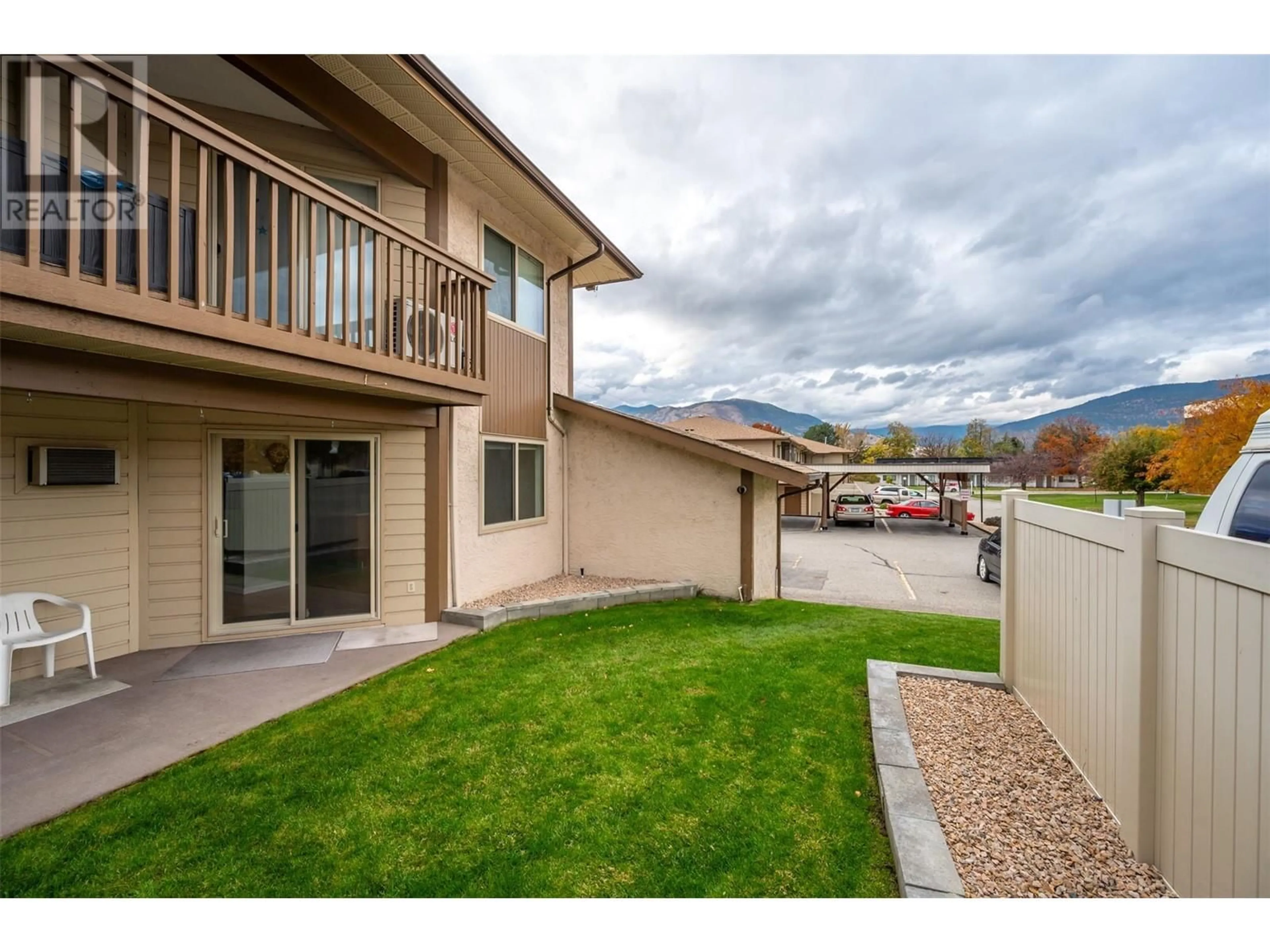 A pic from exterior of the house or condo, the fenced backyard for 1860 Atkinson Street Unit# 106, Penticton British Columbia V2A7M6