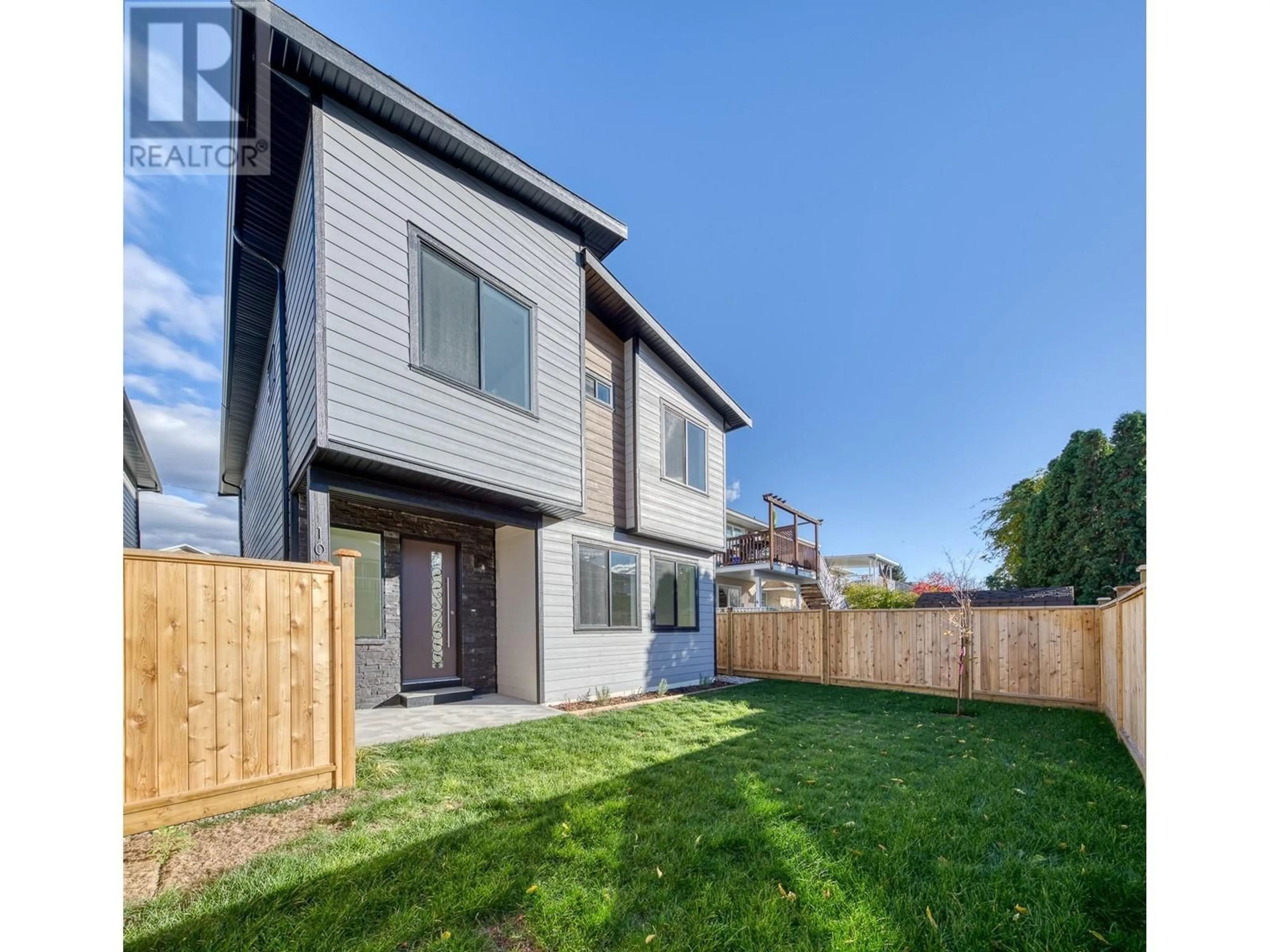 Frontside or backside of a home, the fenced backyard for 1715 Fairford Drive Unit# 102, Penticton British Columbia V2A6C7