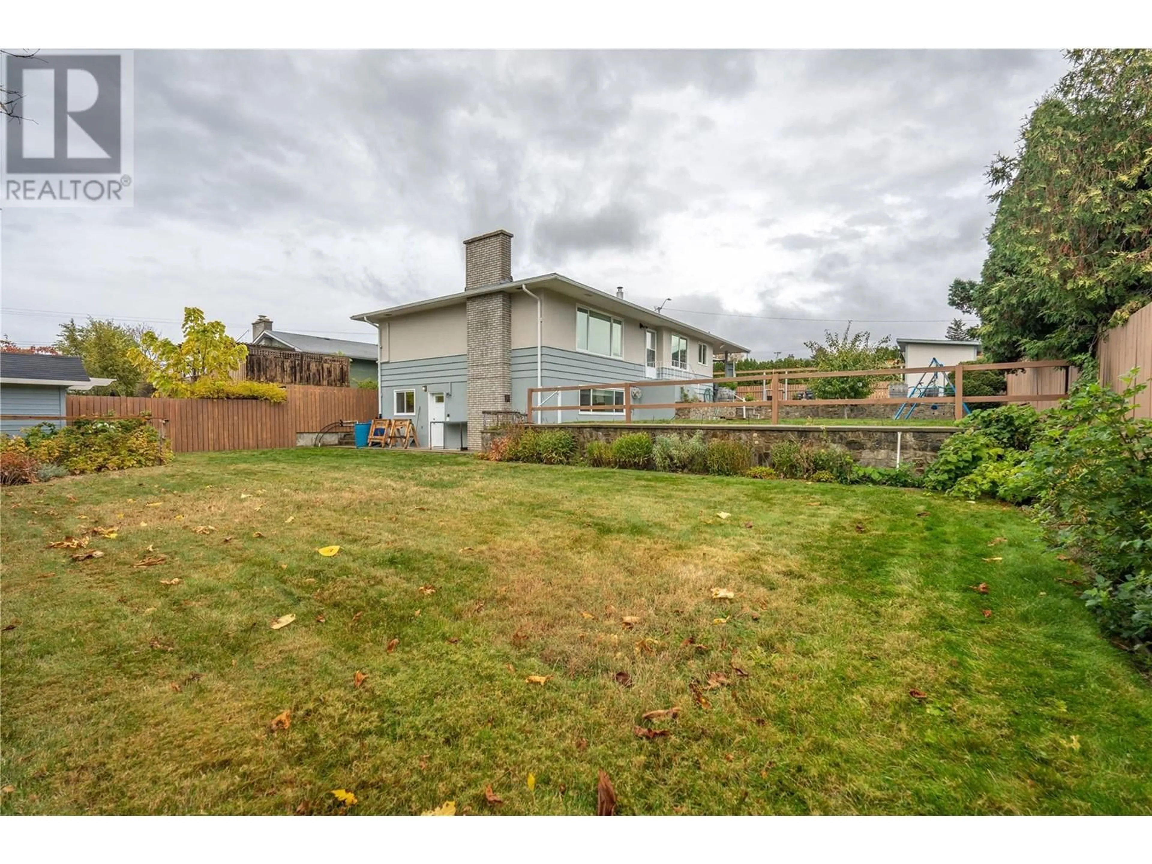 Frontside or backside of a home, the fenced backyard for 1465 Dartmouth Street, Penticton British Columbia V2A4B7