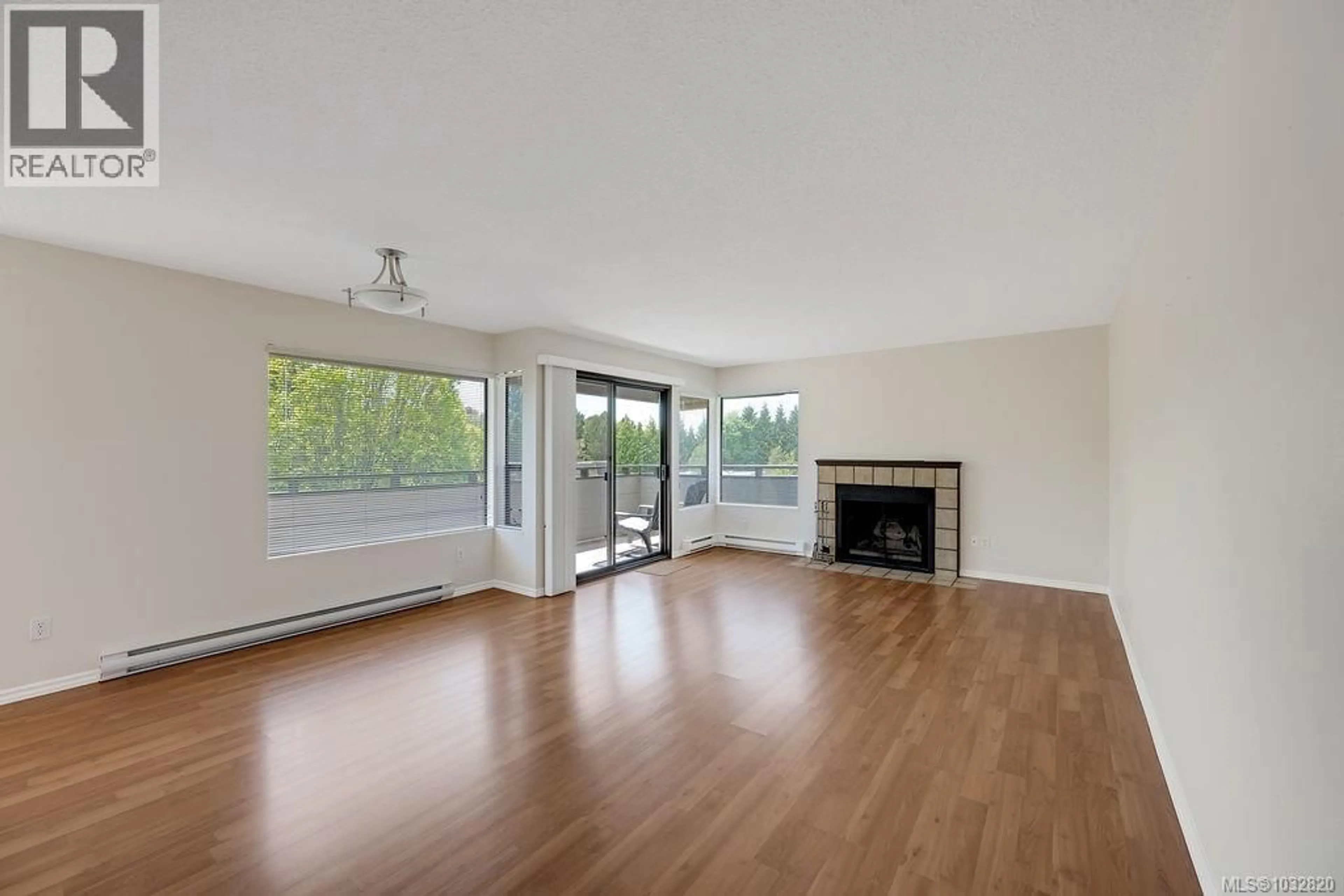 Living room with furniture, wood/laminate floor for 402 - 3274 GLASGOW AVENUE, Saanich British Columbia V8X1M2