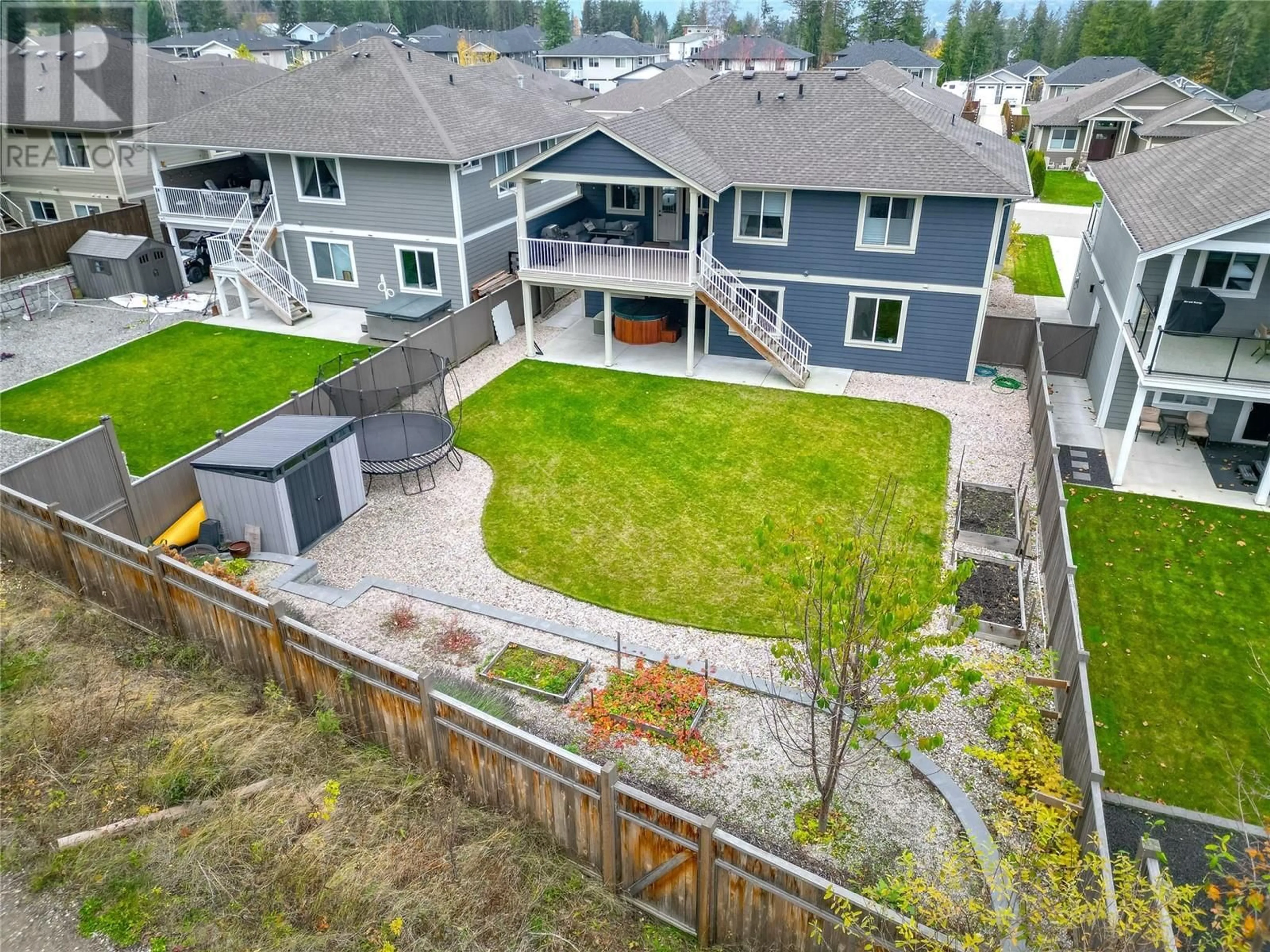 Frontside or backside of a home, the fenced backyard for 1280 24 Street SE, Salmon Arm British Columbia V1E0E3