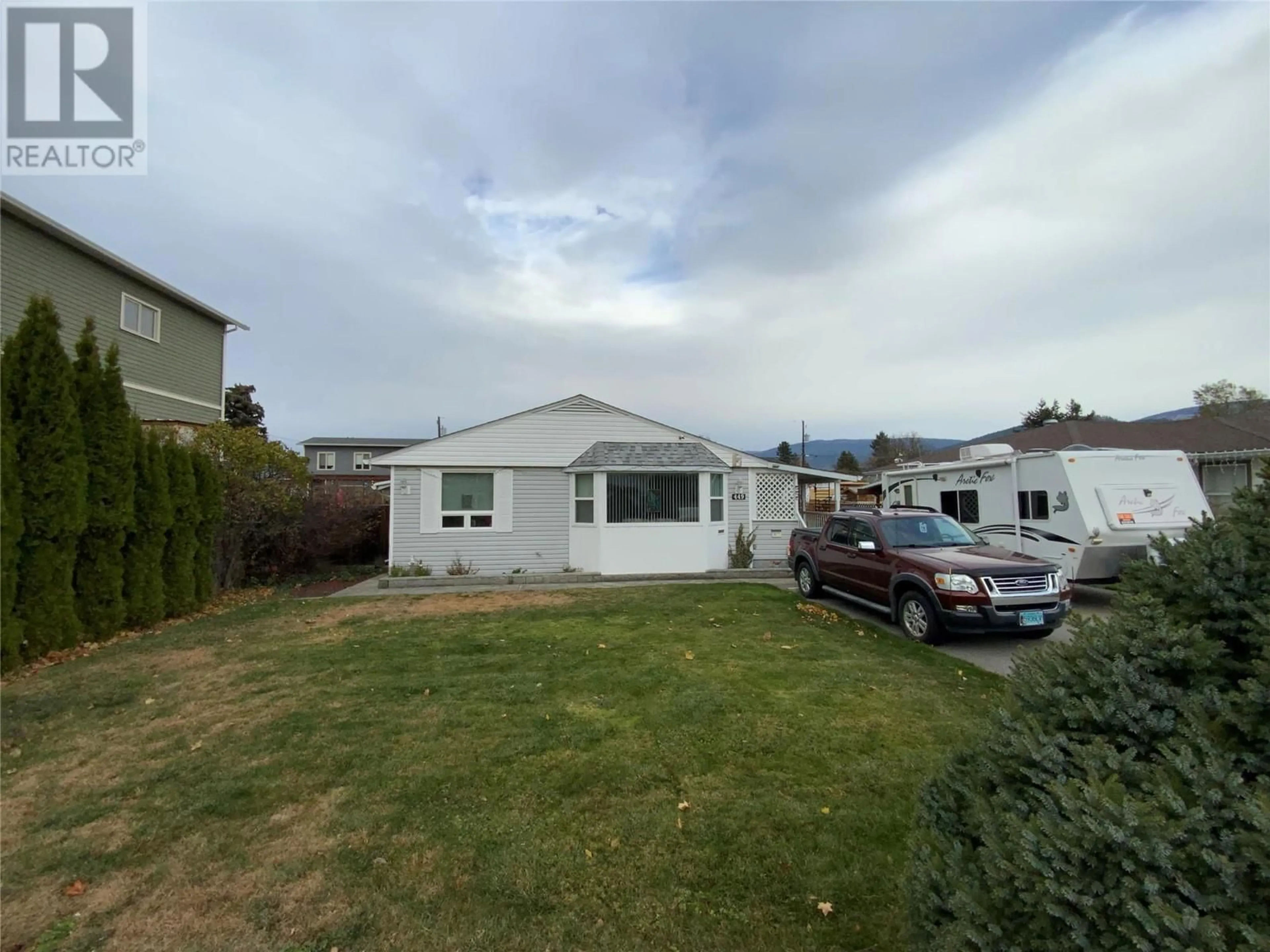 Frontside or backside of a home, the fenced backyard for 449 Conklin Avenue, Penticton British Columbia V2A2T3