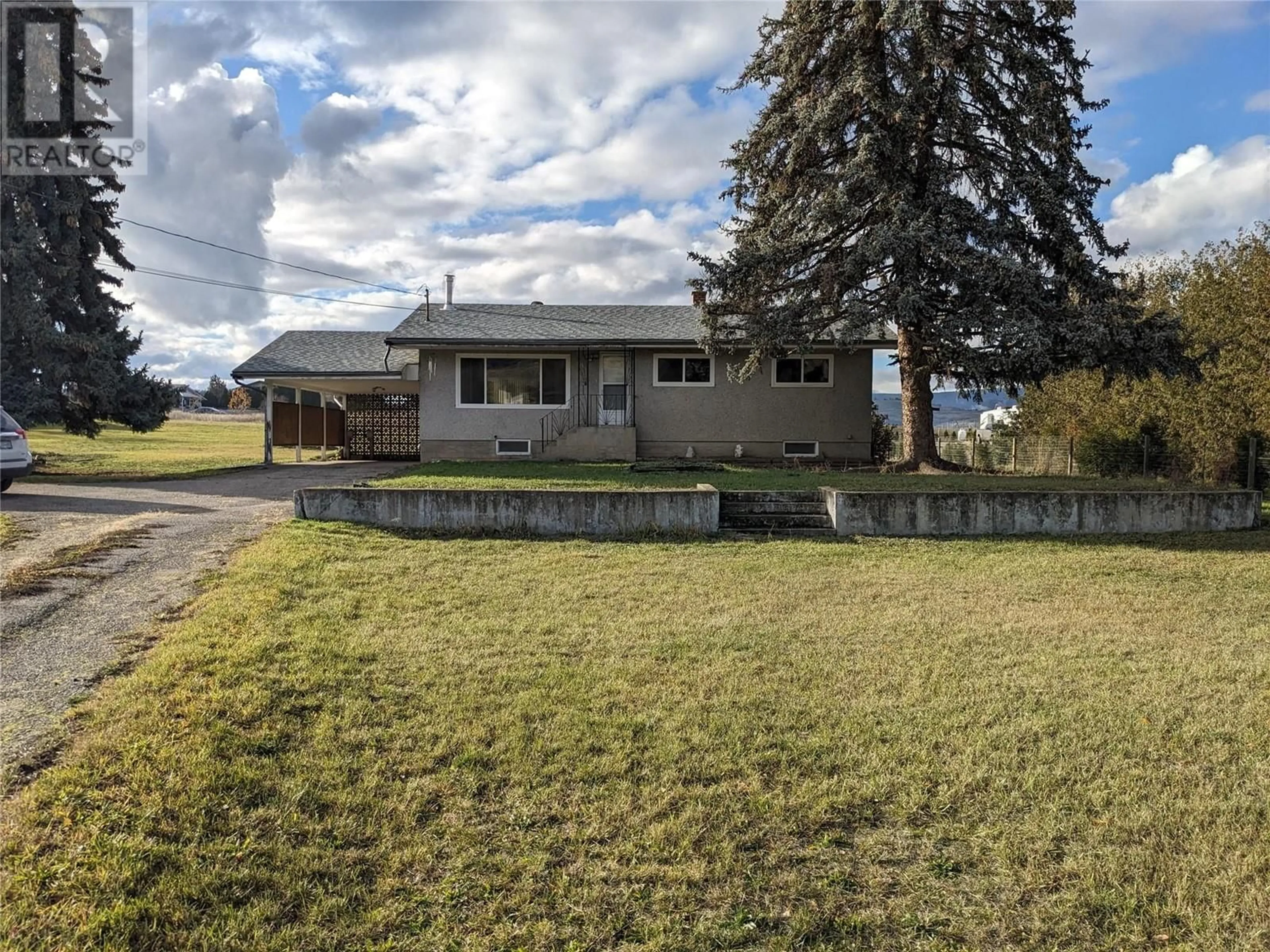 Frontside or backside of a home, the fenced backyard for 6550 Herry Road, Vernon British Columbia V1B3T6