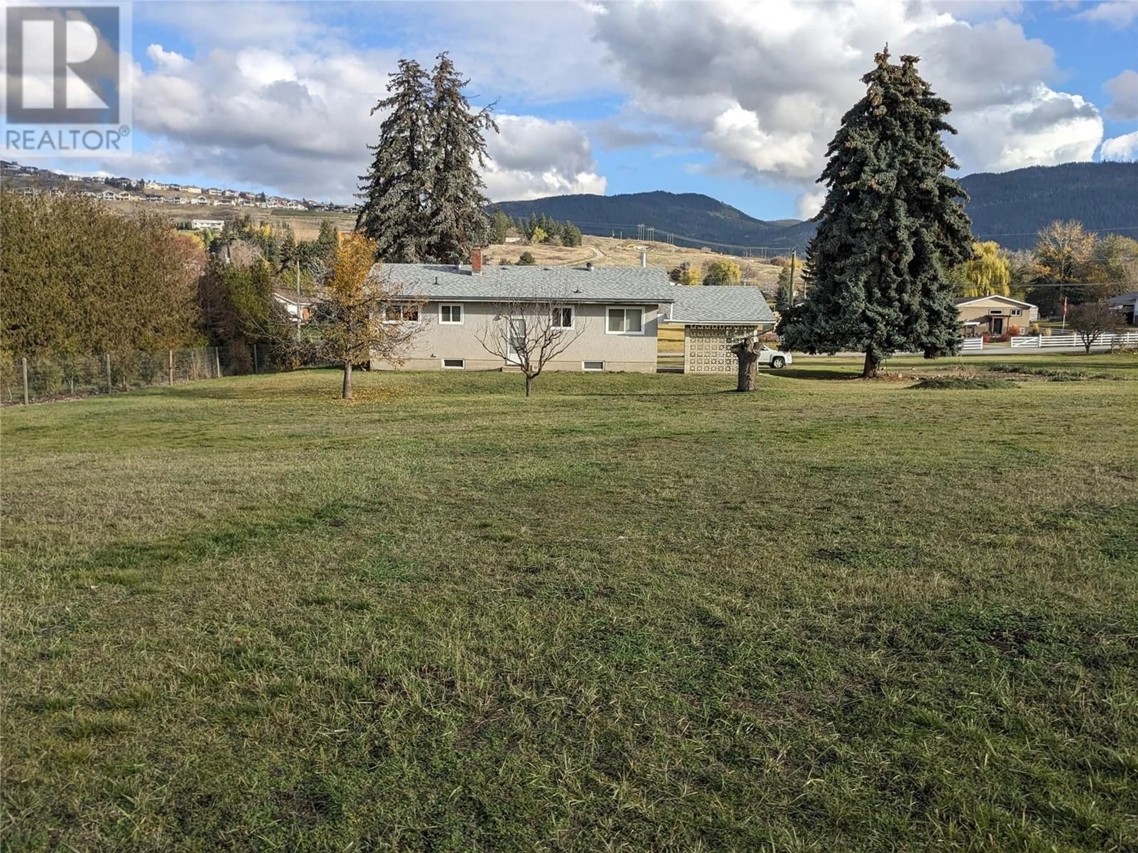 Frontside or backside of a home, the fenced backyard for 6550 Herry Road, Vernon British Columbia V1B3T6