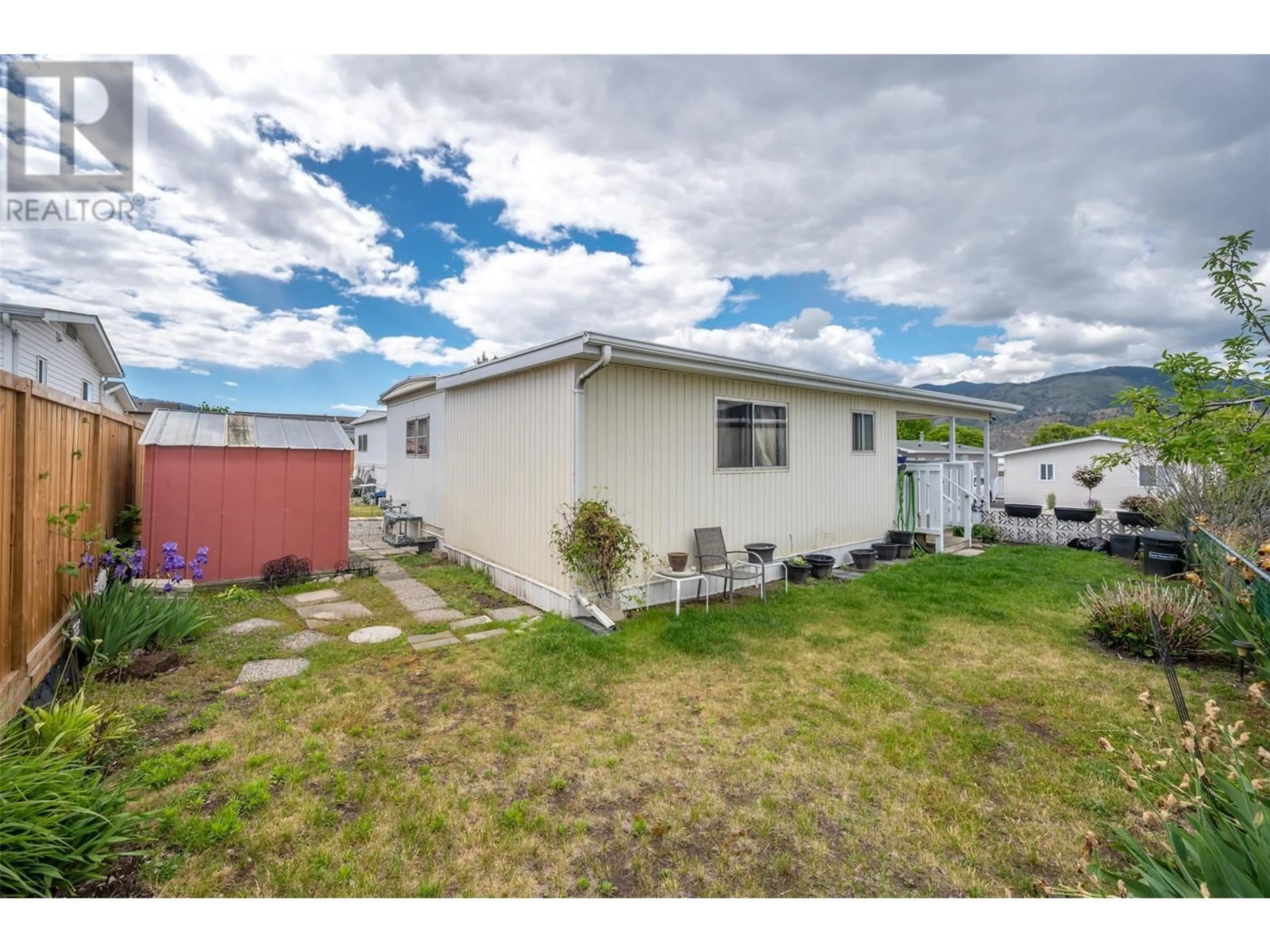 A pic from exterior of the house or condo, the fenced backyard for 98 Okanagan Ave E Avenue Unit# 51, Penticton British Columbia V2A3J5