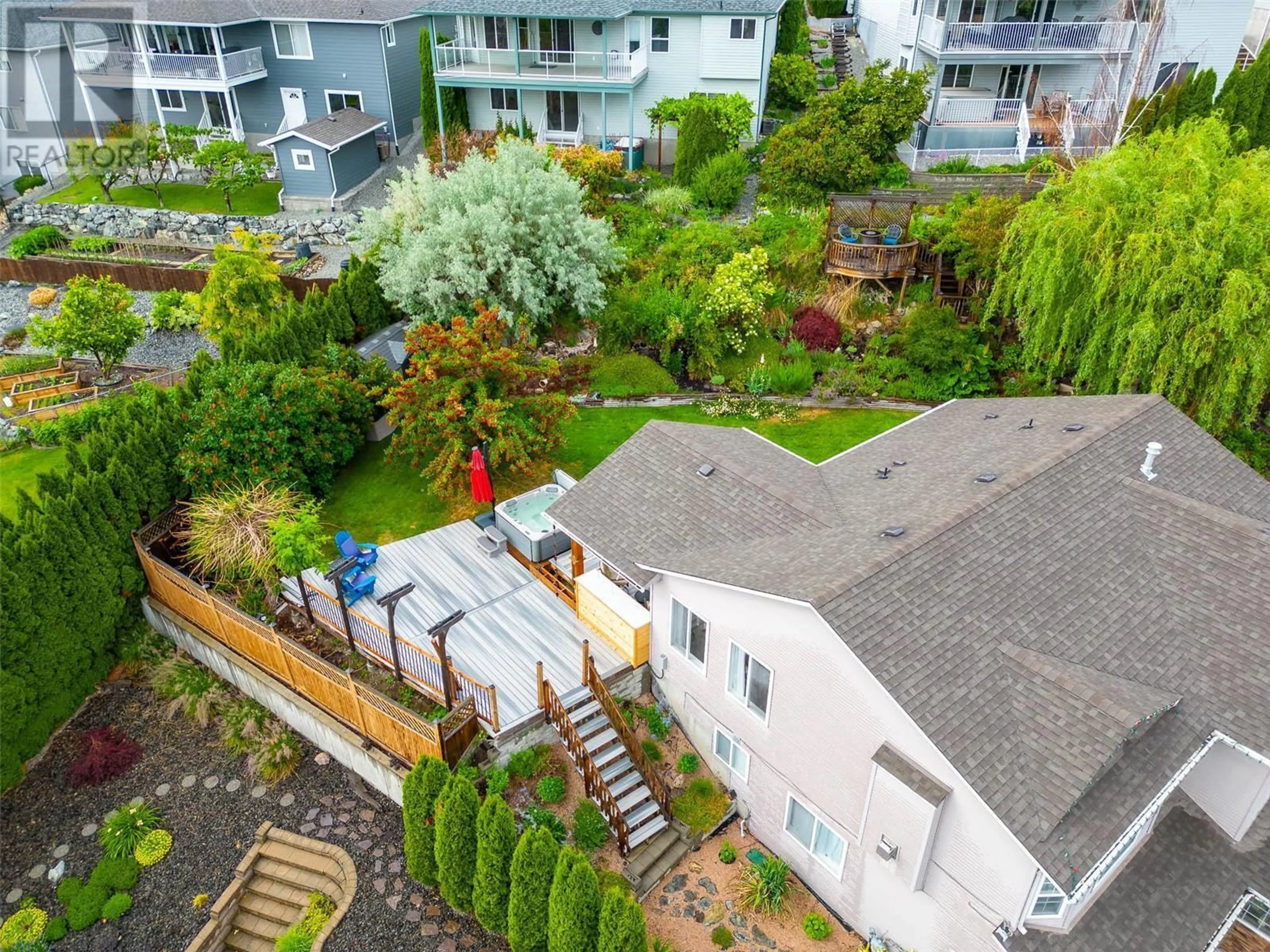 A pic from exterior of the house or condo, the fenced backyard for 1650 Wilmot Court, Kelowna British Columbia V1P1M8