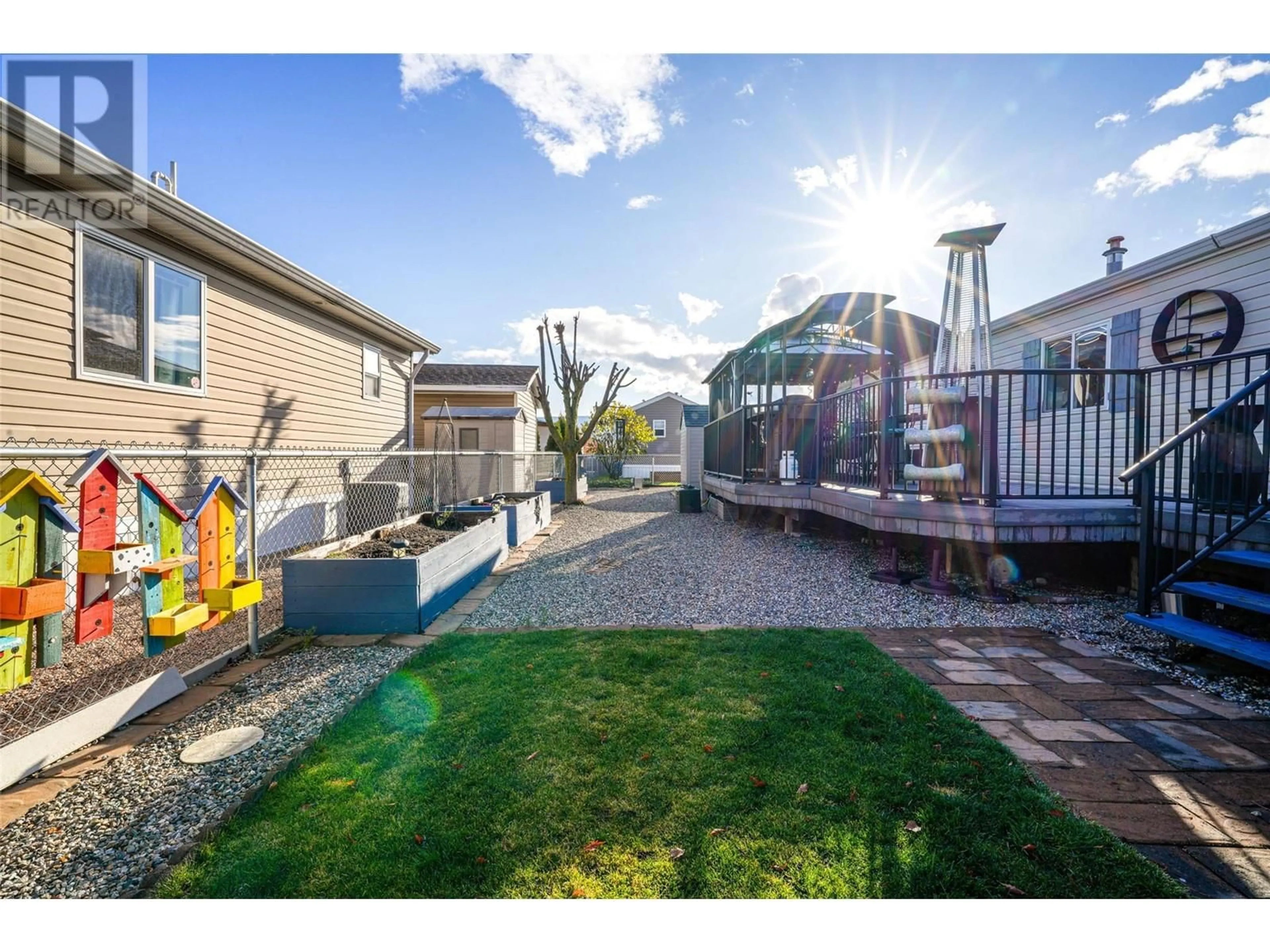 A pic from exterior of the house or condo, the fenced backyard for 12560 Westside Road Unit# 84, Vernon British Columbia V1H1S9