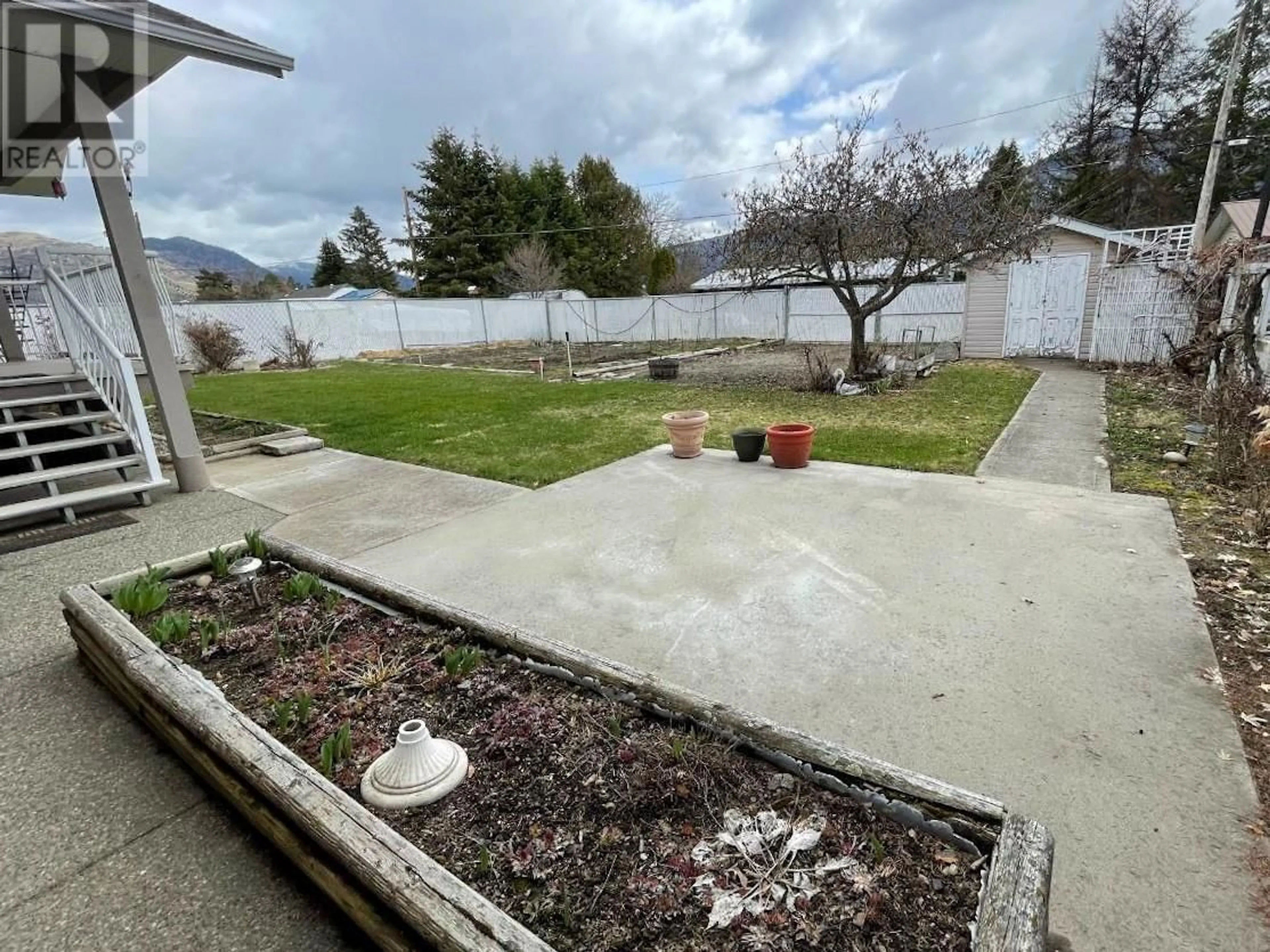 Frontside or backside of a home, the fenced backyard for 2454 75TH Avenue, Grand Forks British Columbia V0H1H2