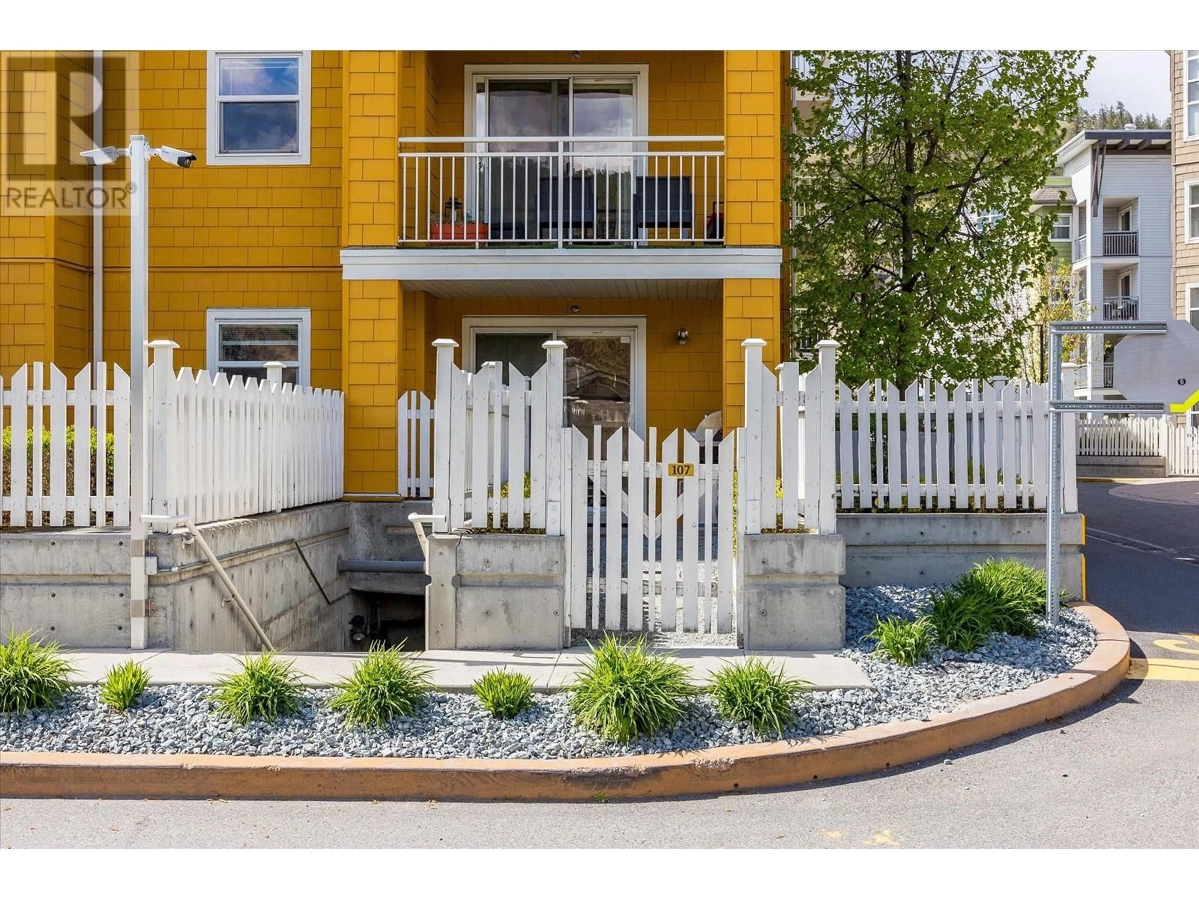 A pic from exterior of the house or condo, the fenced backyard for 571 Yates Road Unit# 107, Kelowna British Columbia V1V2V5