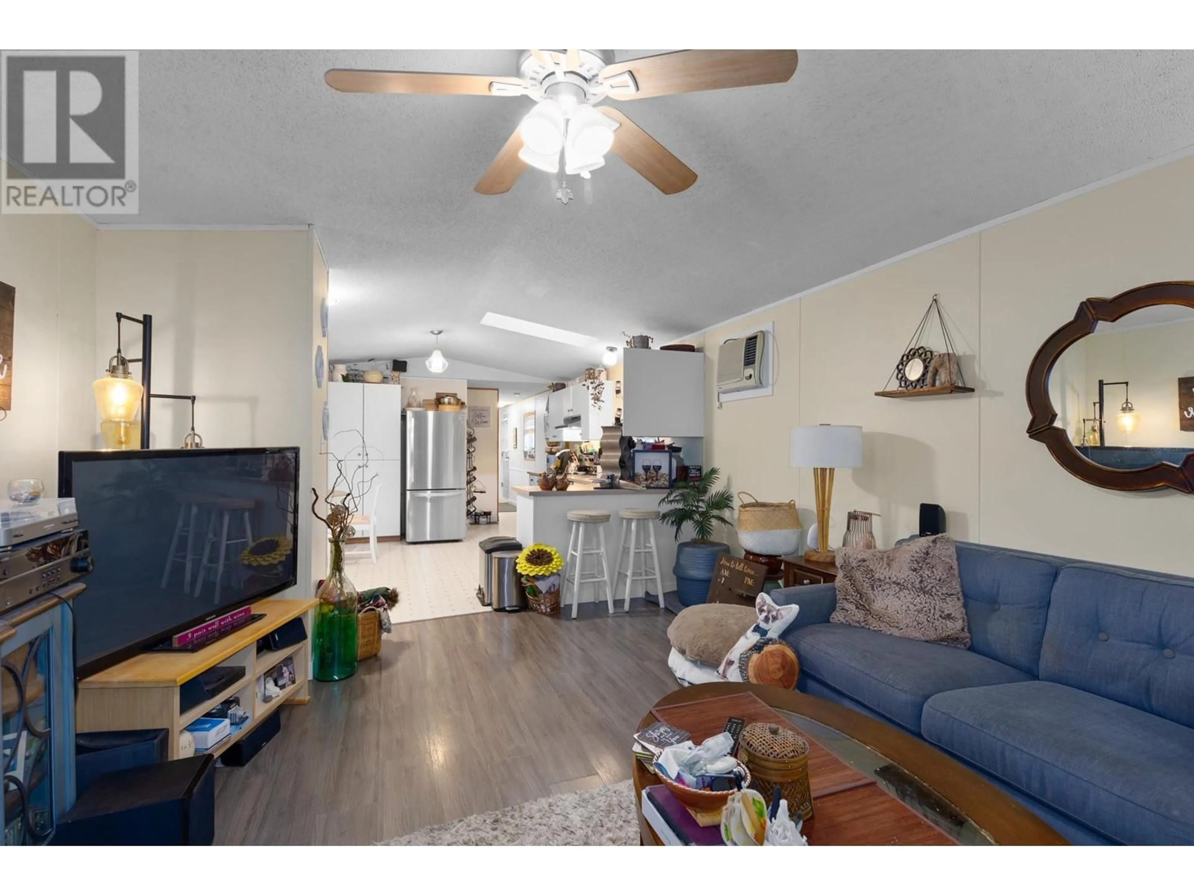 Living room with furniture, wood/laminate floor for 1525 Westside Road S Unit# 54, Kelowna British Columbia V1Z3Y3