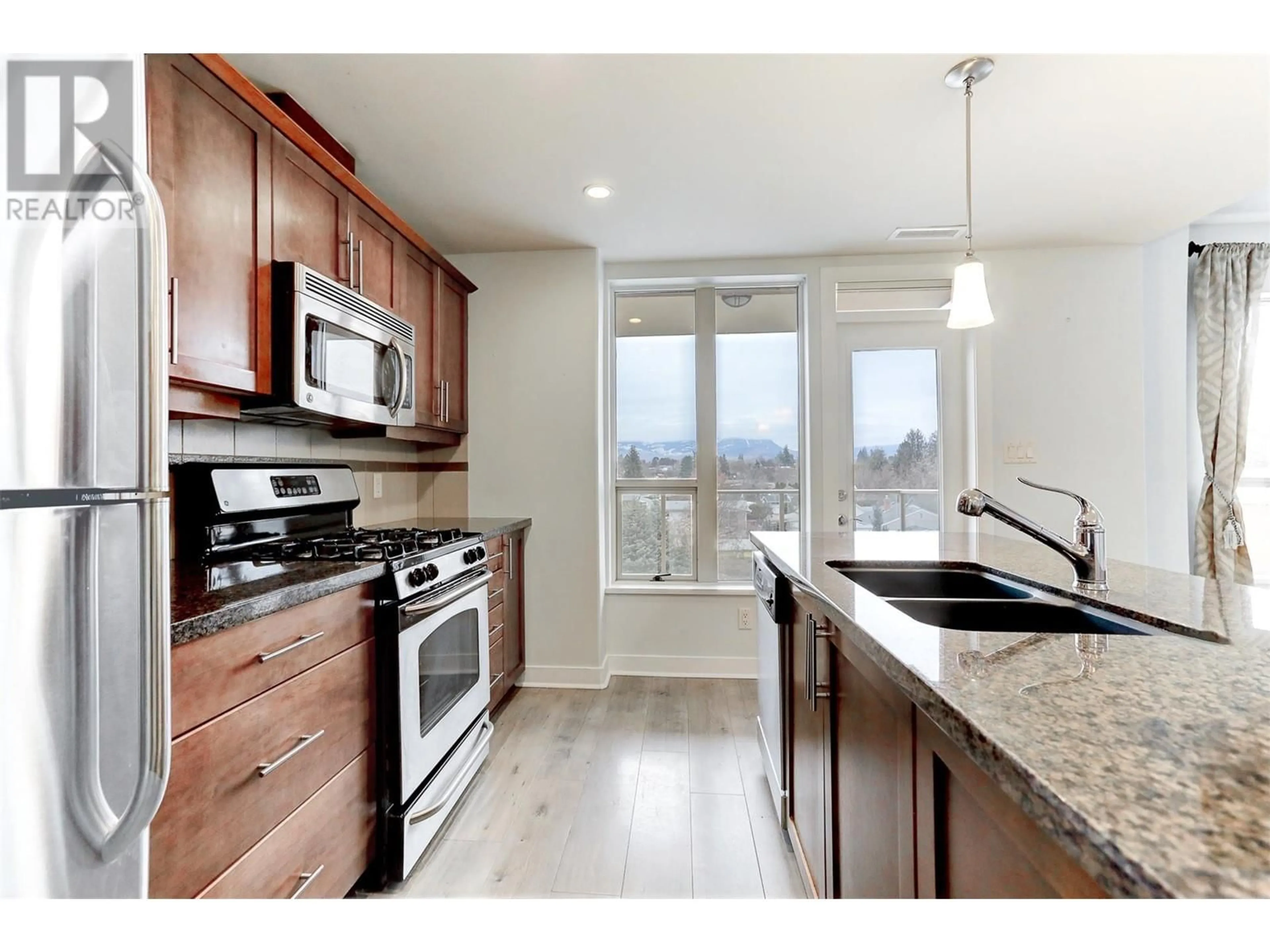 Open concept kitchen, wood/laminate floor for 1160 Bernard Avenue Unit# 304, Kelowna British Columbia V1Y6R2