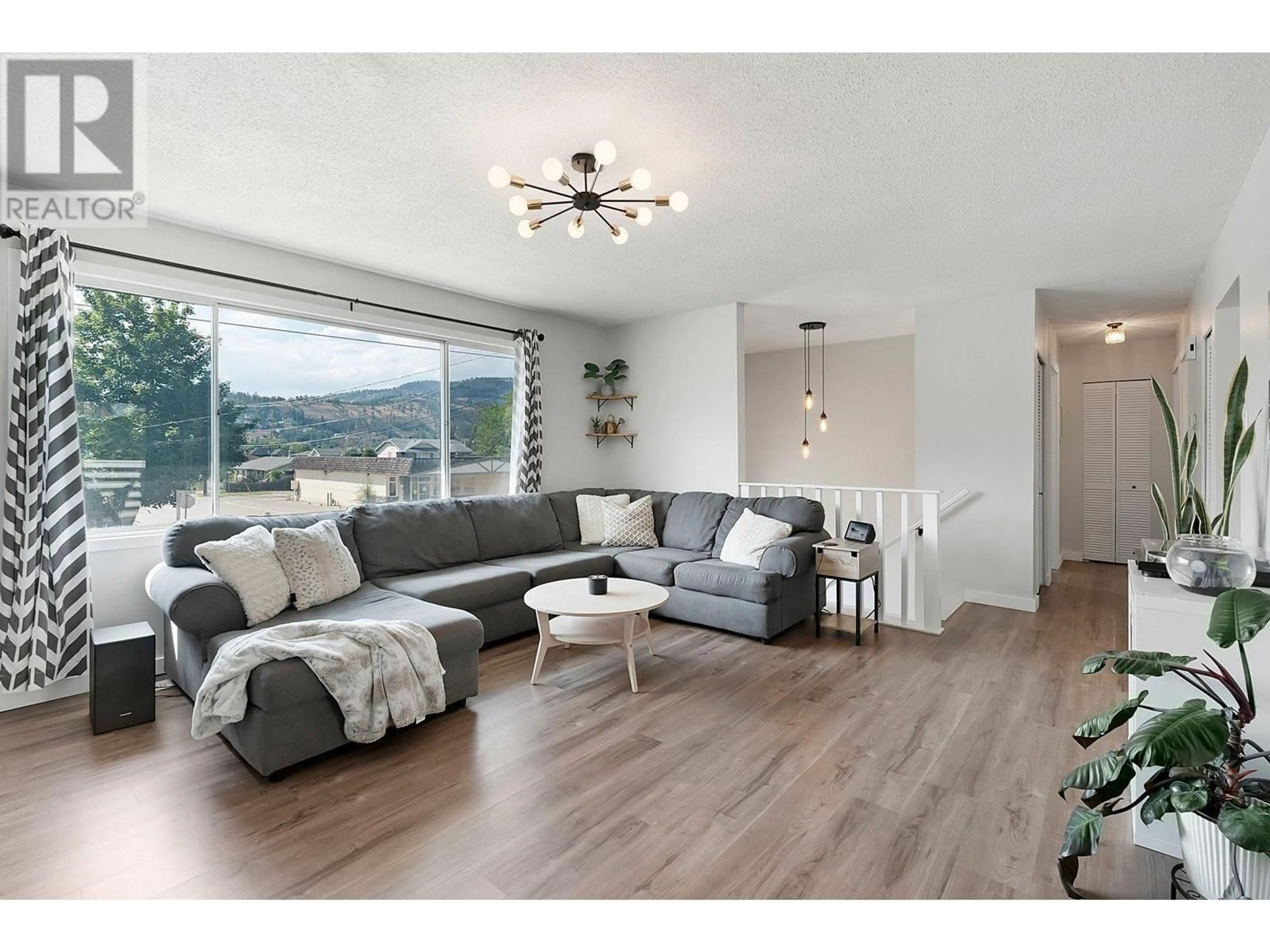 Living room with furniture, wood/laminate floor for 11029 Victoria Road S, Summerland British Columbia V0H1Z2