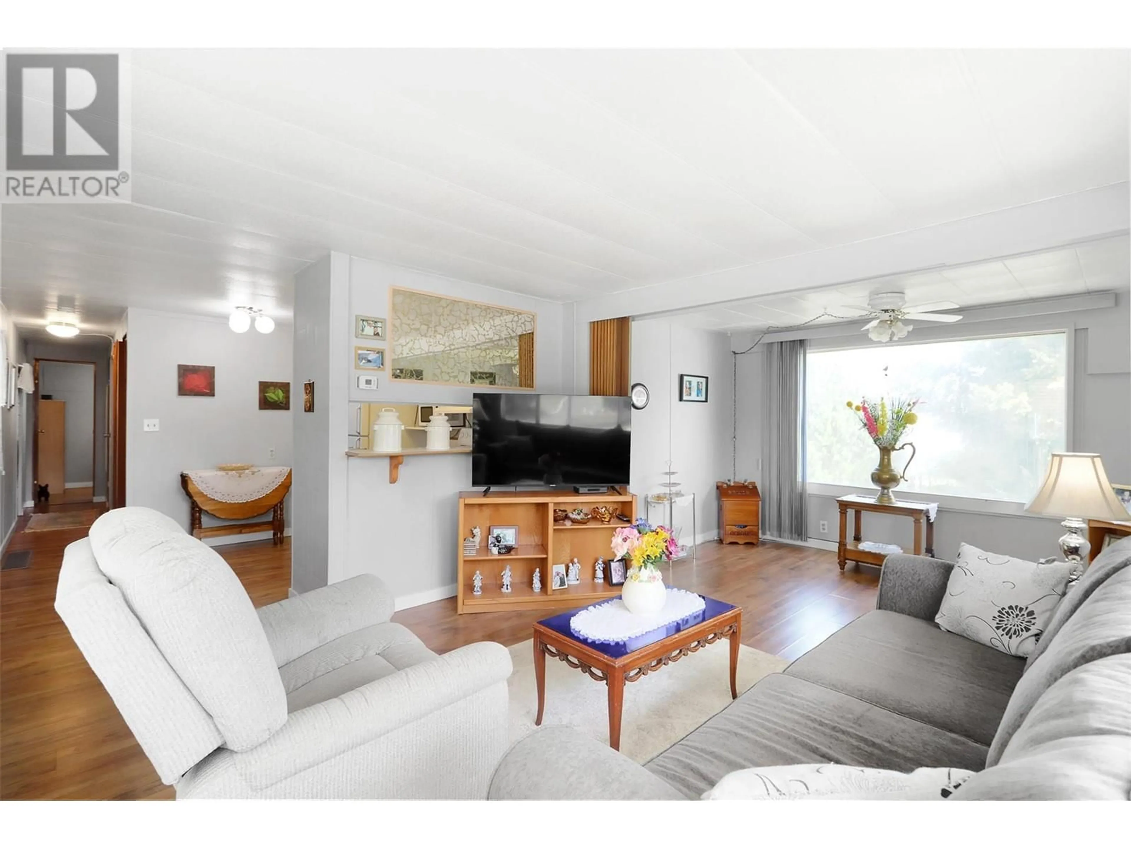 Living room with furniture, wood/laminate floor for 1133 Findlay Road Unit# 63, Kelowna British Columbia V1X5A9