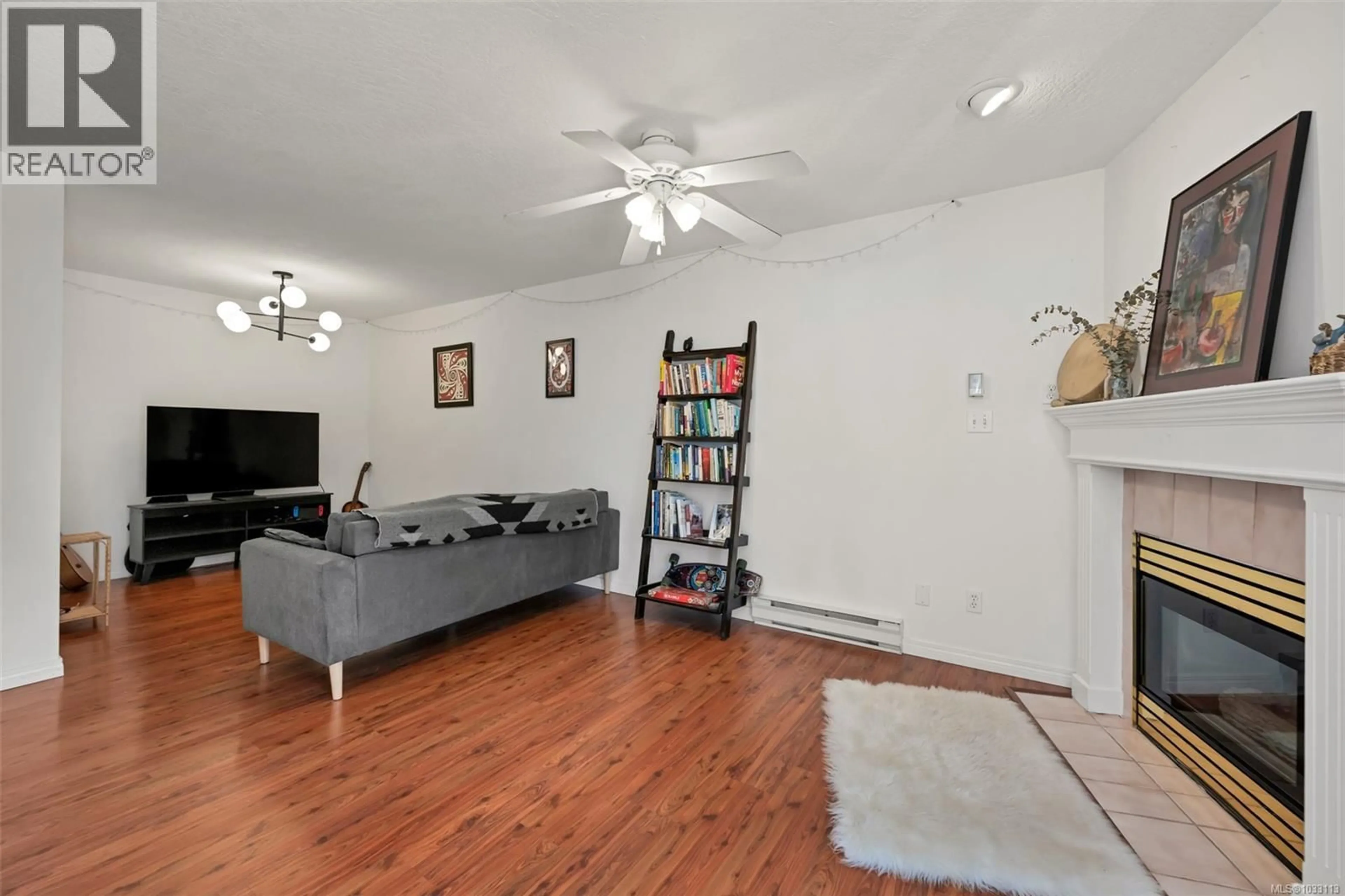 Living room with furniture, wood/laminate floor for 212 - 899 DARWIN AVENUE, Saanich British Columbia V8X2X7