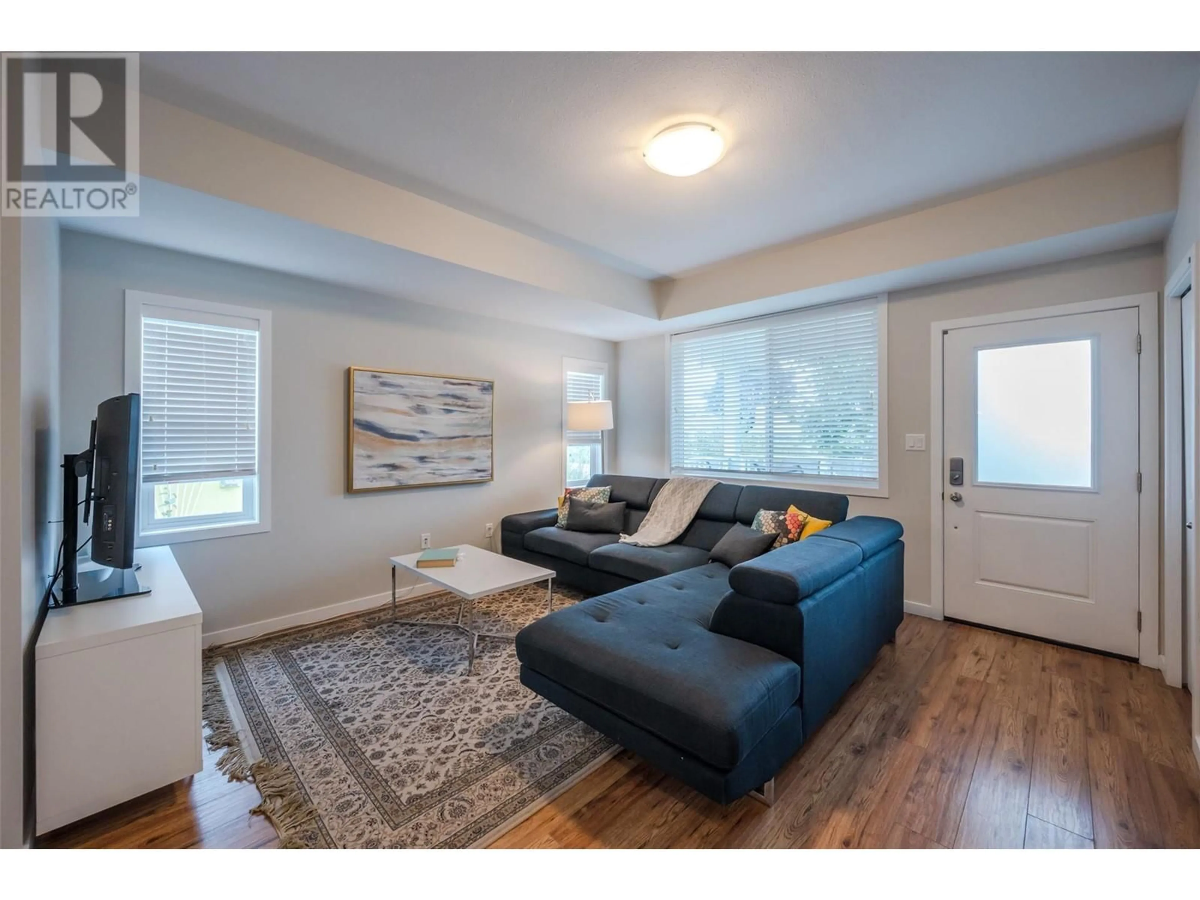 Living room with furniture, wood/laminate floor for 223 Conklin Avenue Unit# 101, Penticton British Columbia V2A2T1