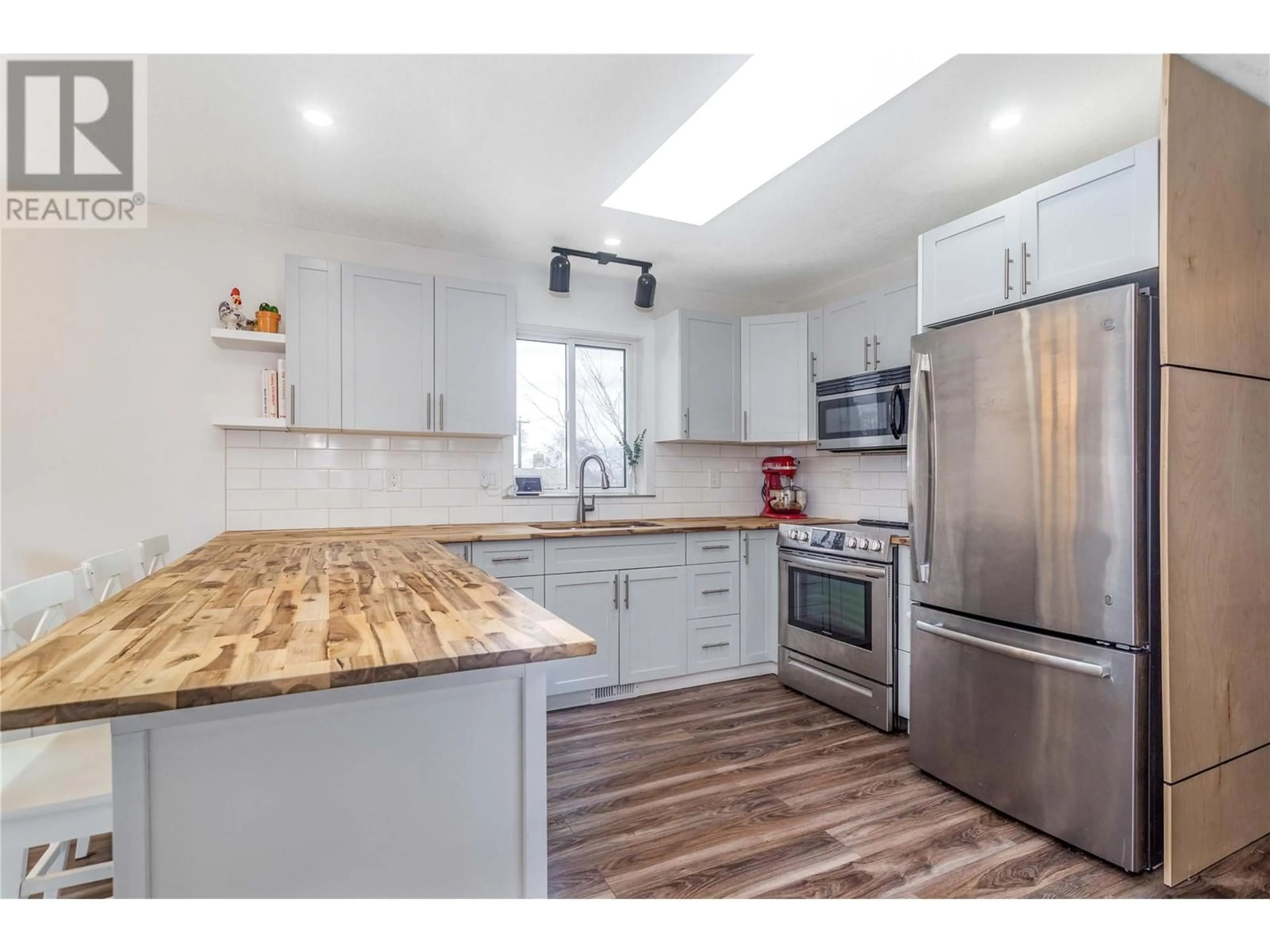 Open concept kitchen, wood/laminate floor for 1612 33 Street, Vernon British Columbia V1T5P7