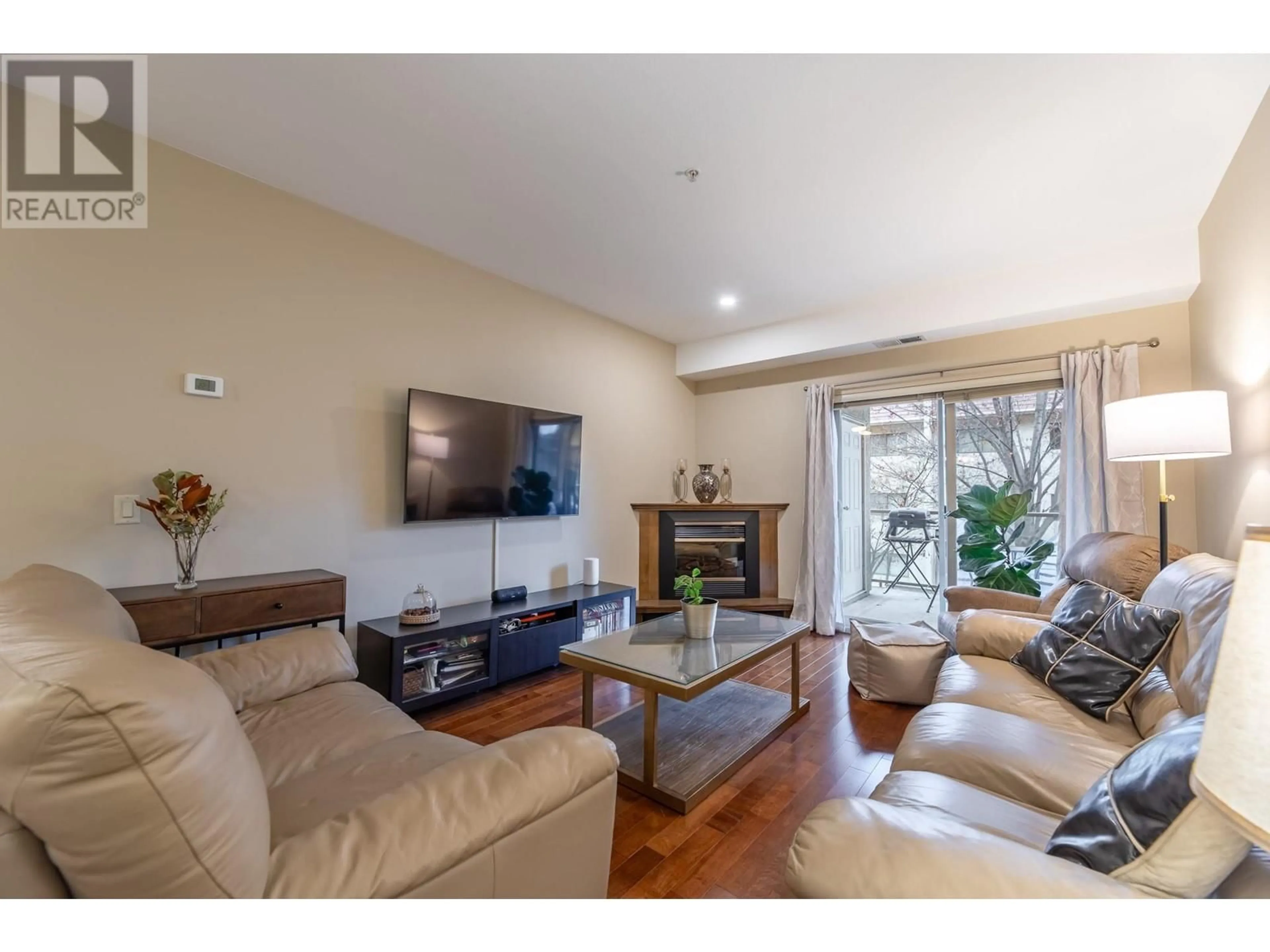 Living room with furniture, wood/laminate floor for 1007 Harvey Avenue Unit# 206, Kelowna British Columbia V1Y6E4