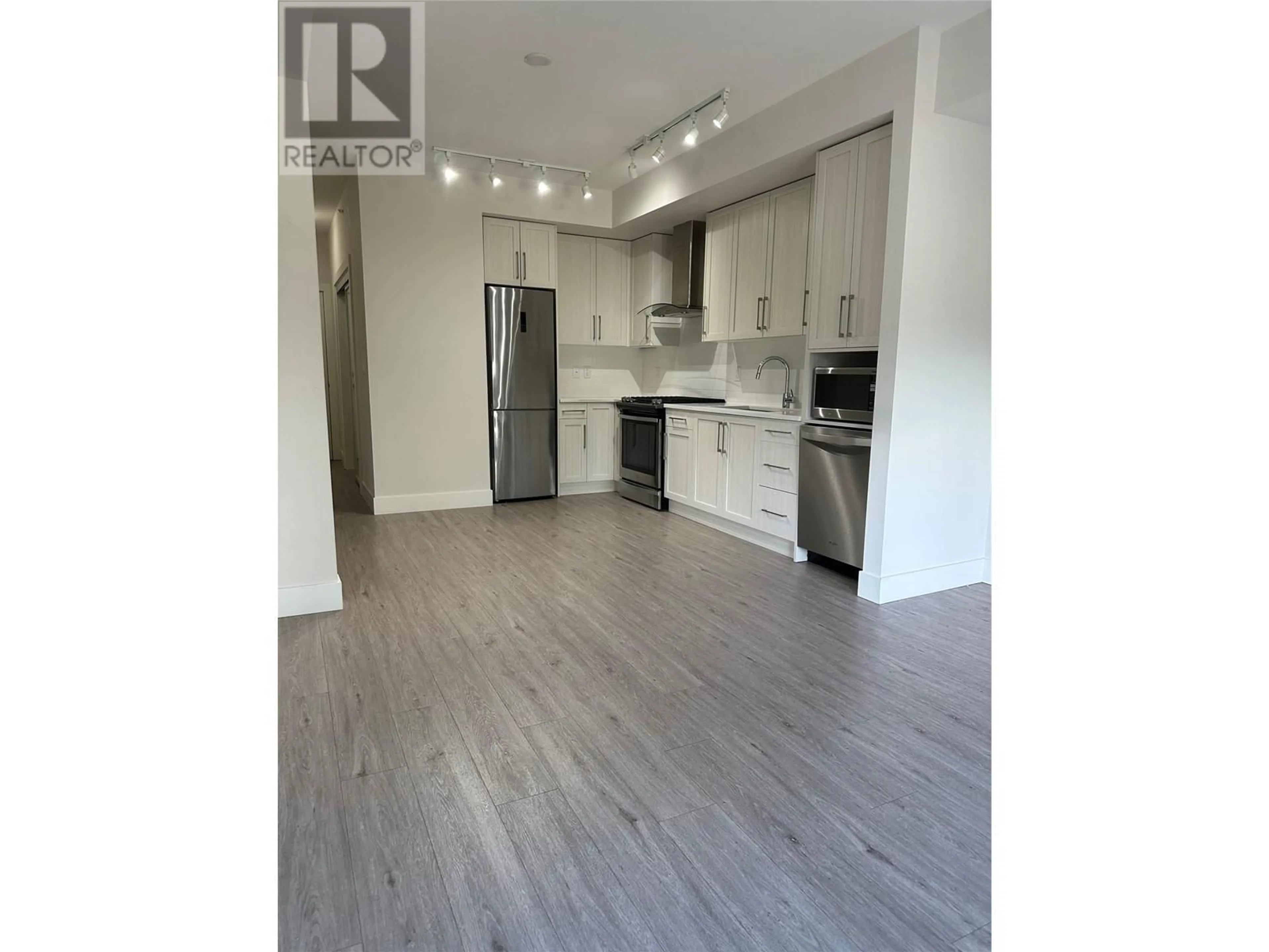 Open concept kitchen, wood/laminate floor for 4380 Lakeshore Road Unit# PH16, Kelowna British Columbia V1Y0B5