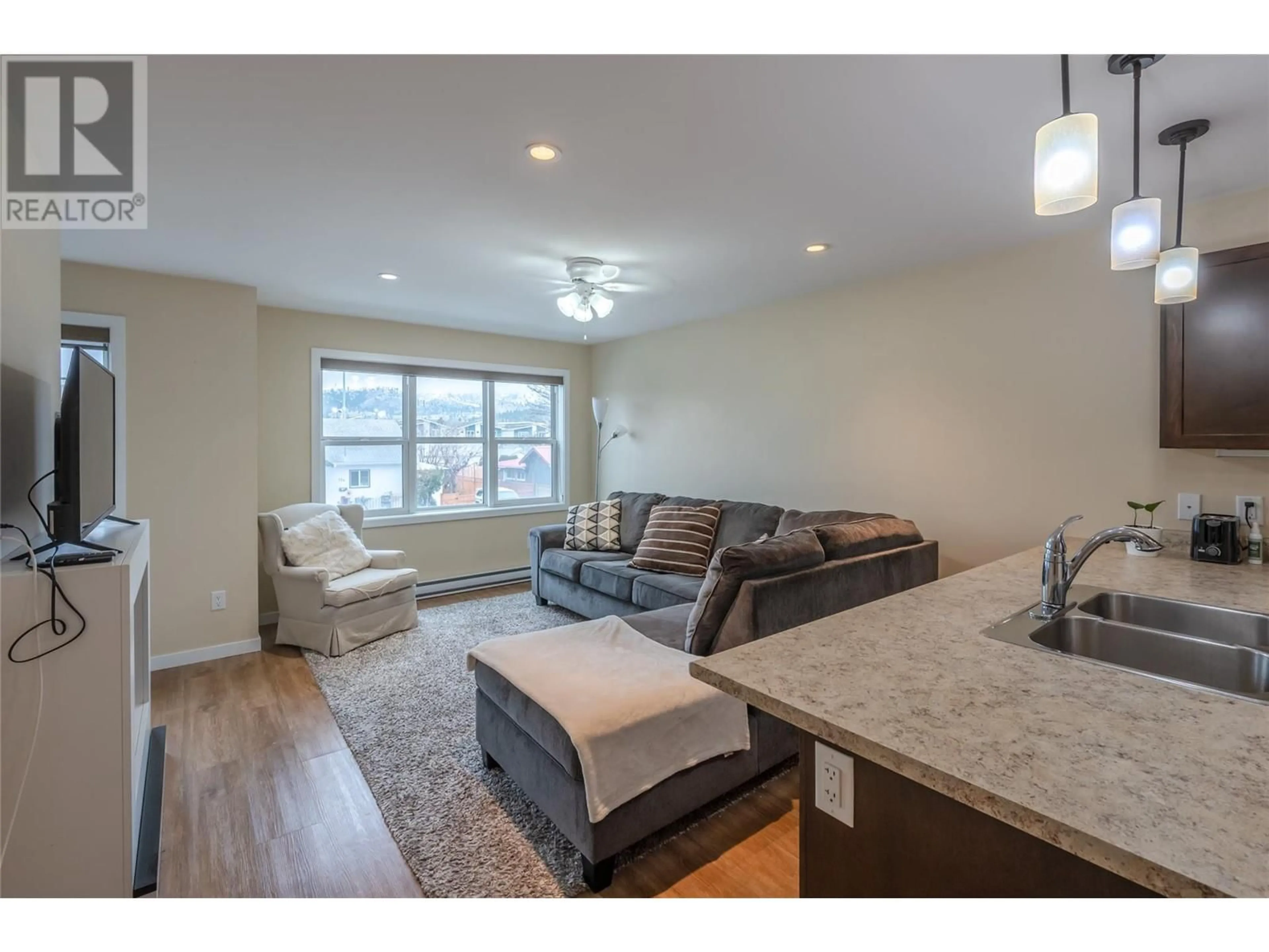 Living room with furniture, wood/laminate floor for 707 Revelstoke Avenue Unit# 105, Penticton British Columbia V2A2J1