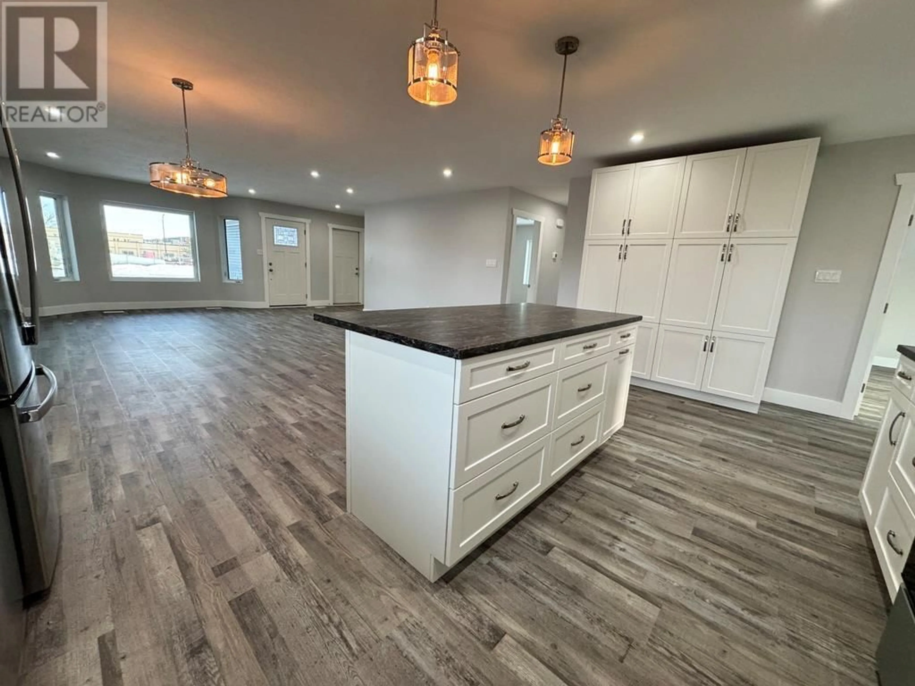 Open concept kitchen, wood/laminate floor for 1009 116 Avenue, Dawson Creek British Columbia V1G3E4