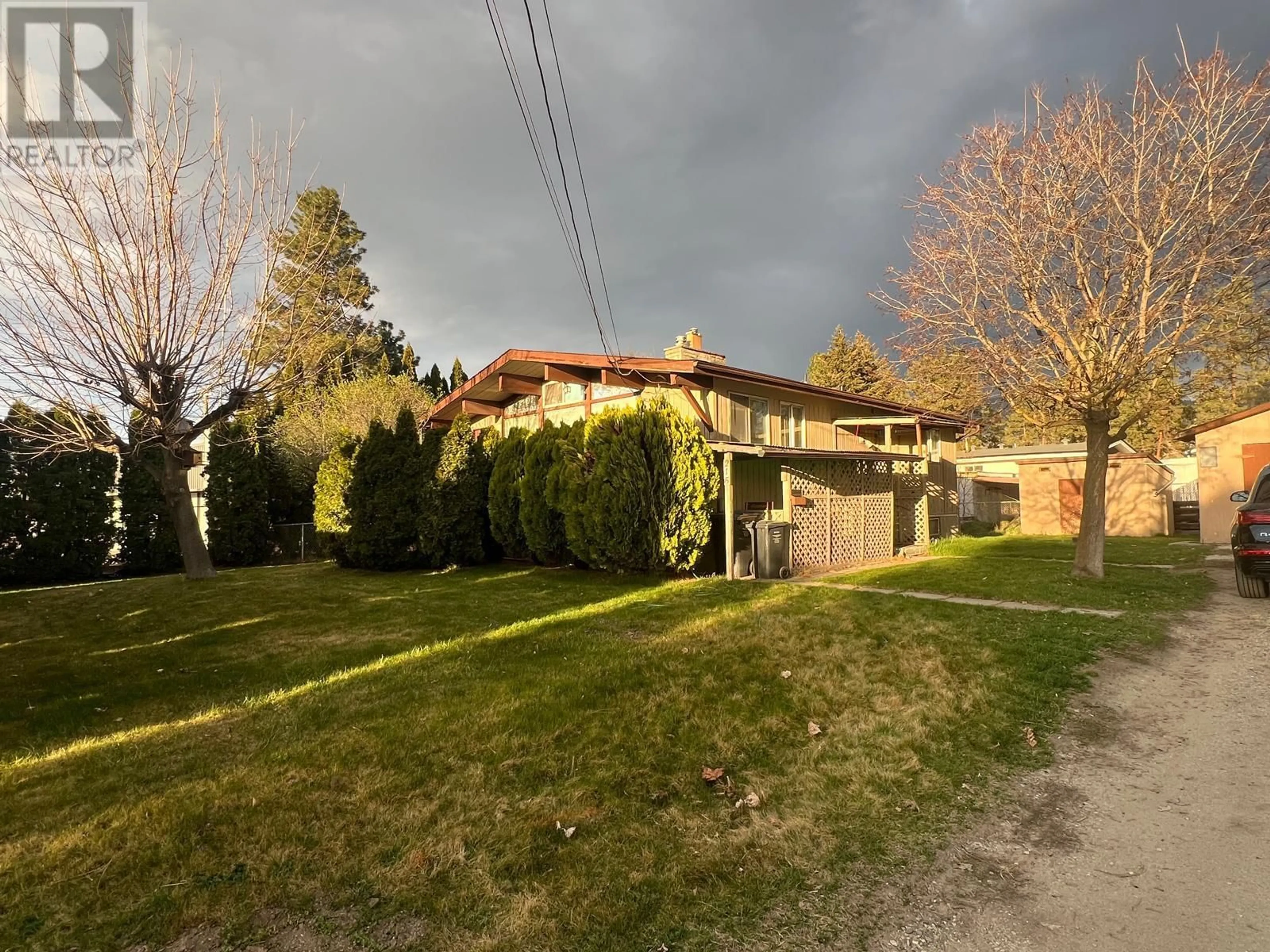 A pic from outside/outdoor area/front of a property/back of a property/a pic from drone, street for 215 Cambie Road, Kelowna British Columbia V1X3H9