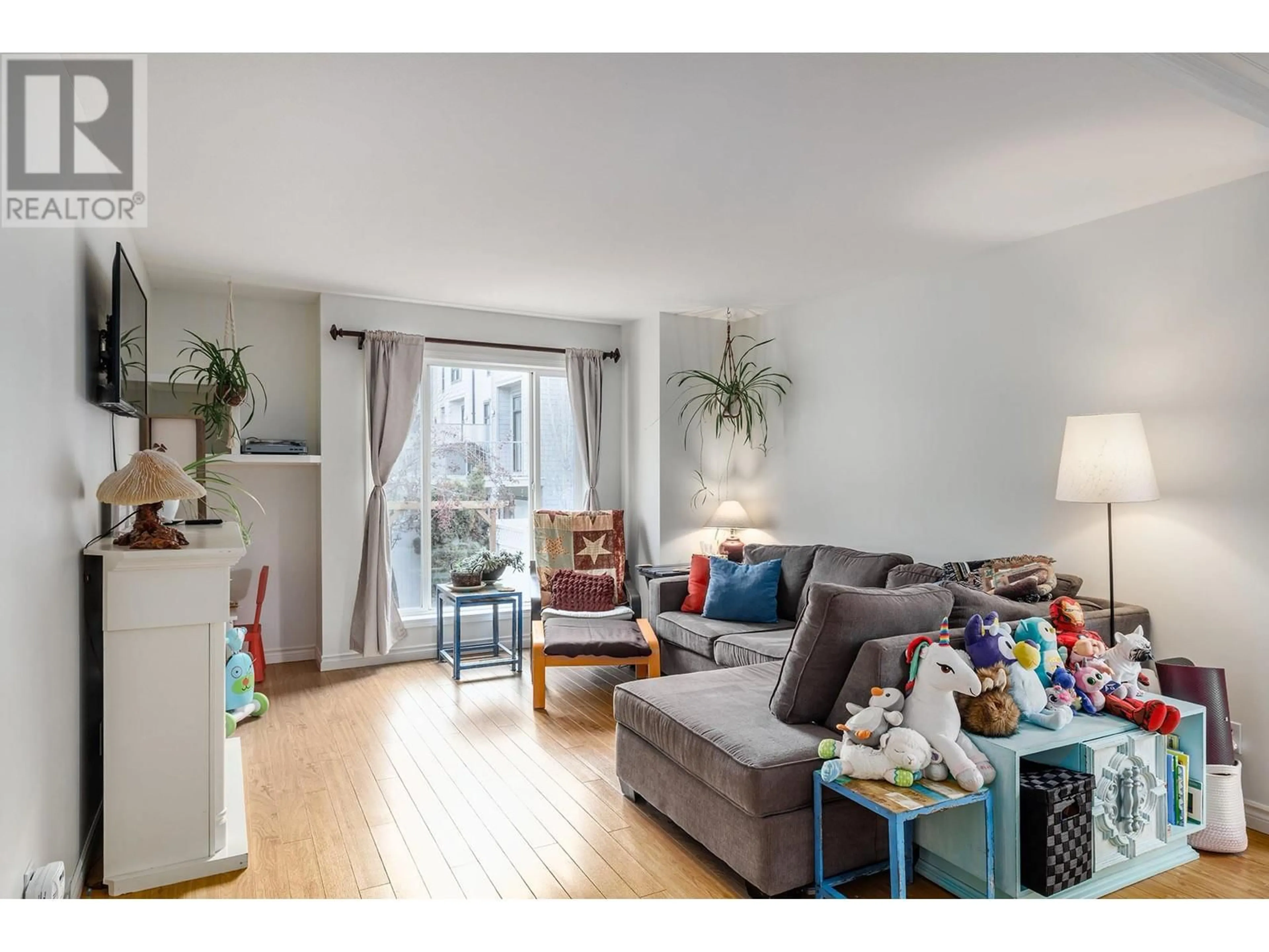 Living room with furniture, wood/laminate floor for 160 Celano Crescent Unit# 131, Kelowna British Columbia V1X1X9