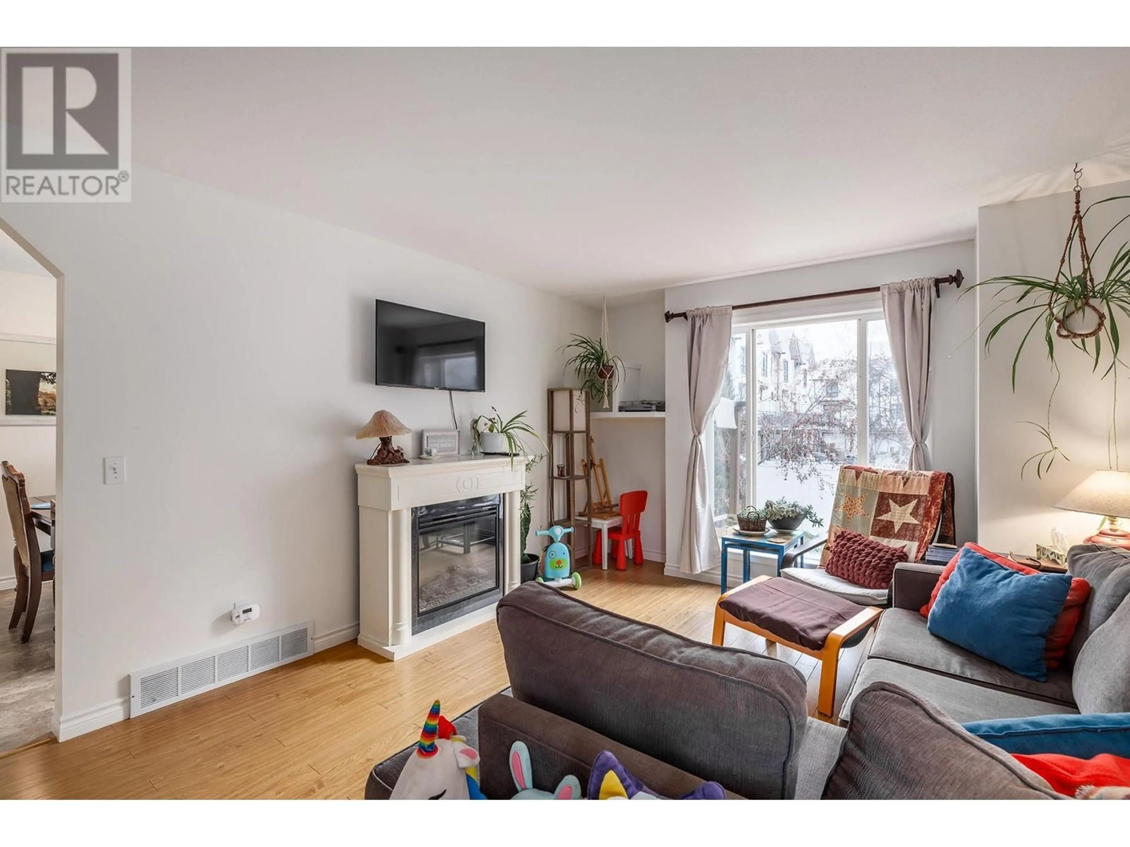 Living room with furniture, wood/laminate floor for 160 Celano Crescent Unit# 131, Kelowna British Columbia V1X1X9