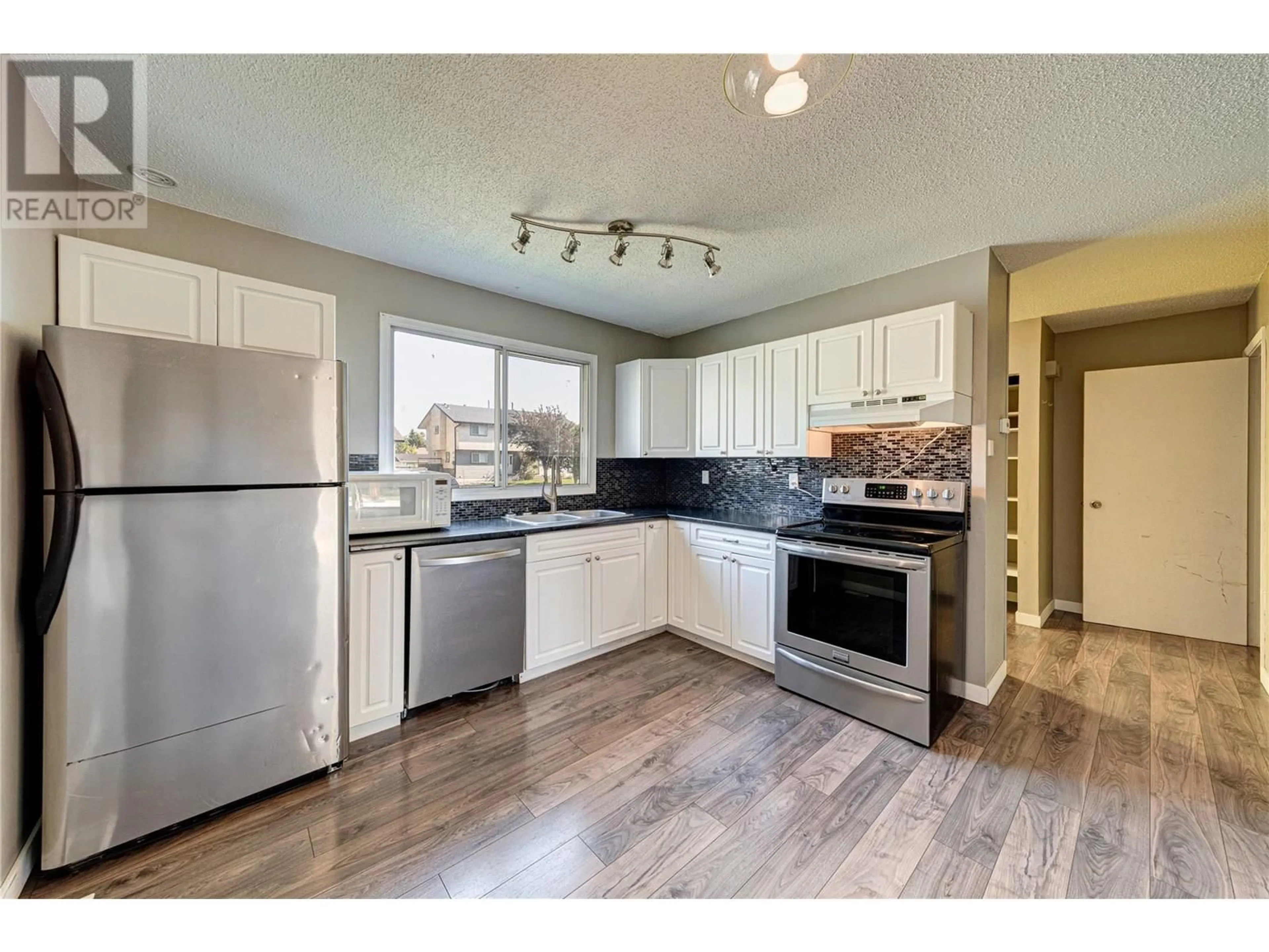 Open concept kitchen, wood/laminate floor for 403A MOUNTAIN ASH CRESCENT, Sparwood British Columbia V0B2G1