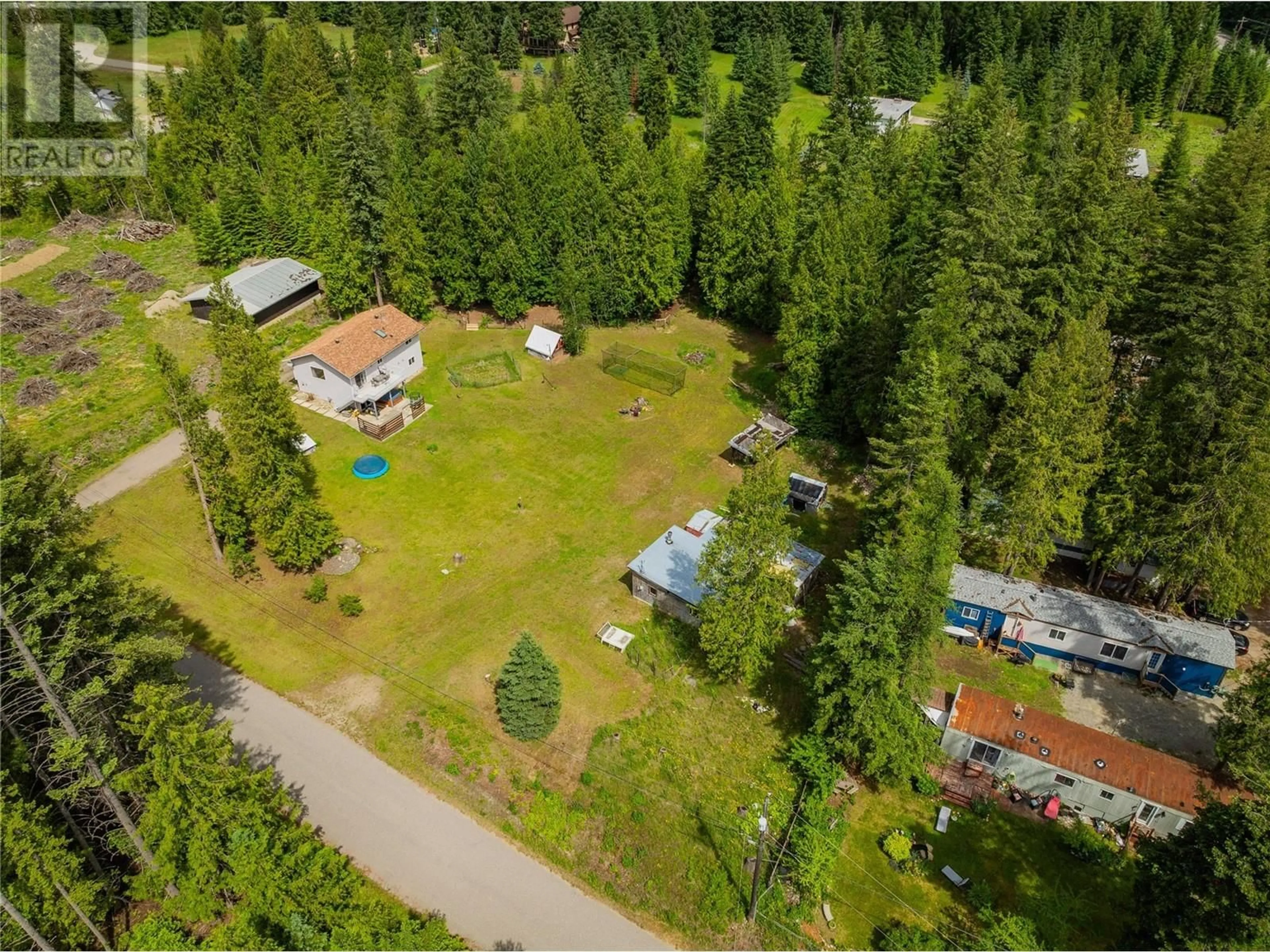 A pic from outside/outdoor area/front of a property/back of a property/a pic from drone, forest/trees view for 982 Kelly Drive, Castlegar British Columbia V1N4P5