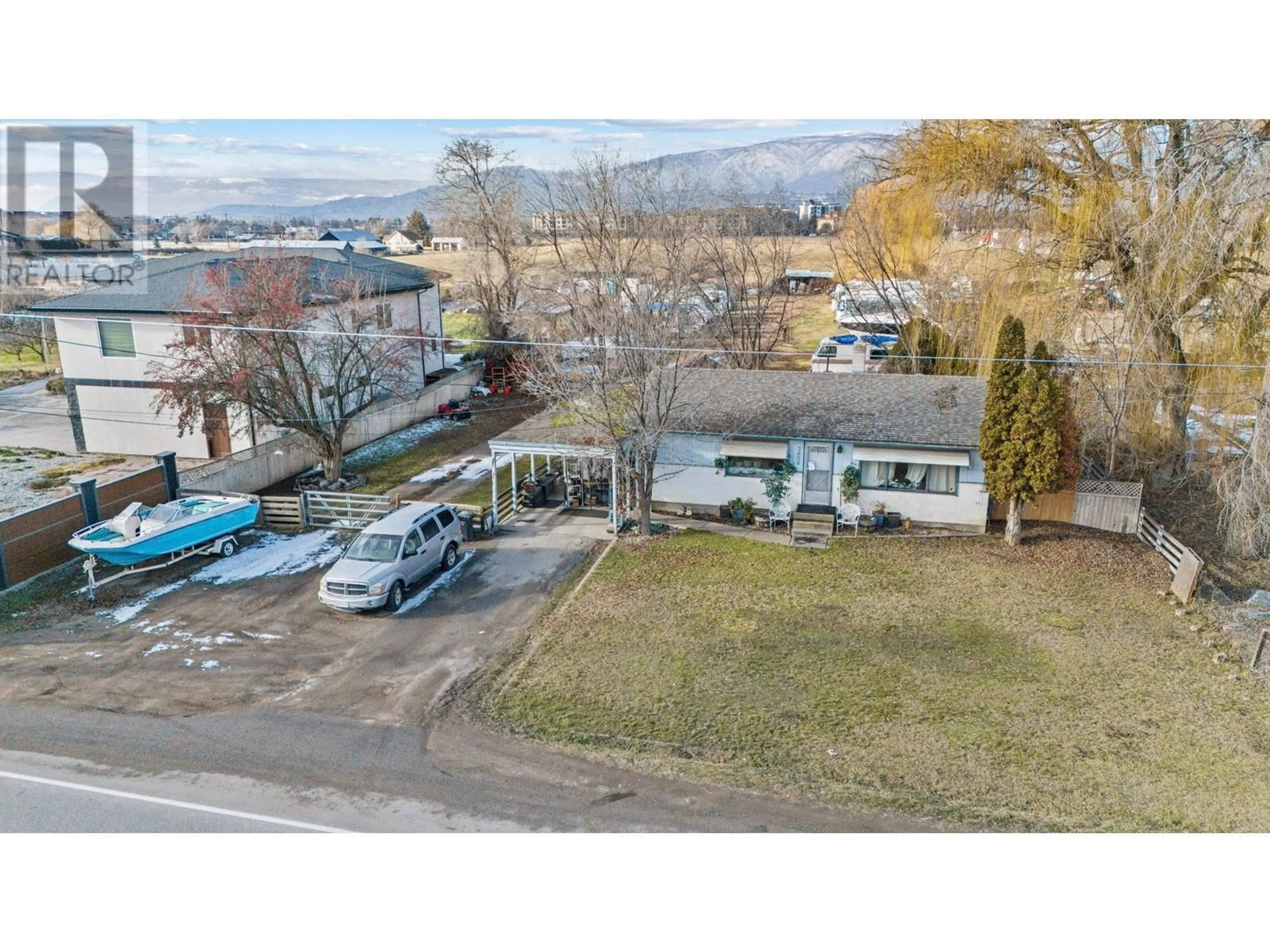 A pic from outside/outdoor area/front of a property/back of a property/a pic from drone, mountain view for 3656 Benvoulin Road, Kelowna British Columbia V1W4M7