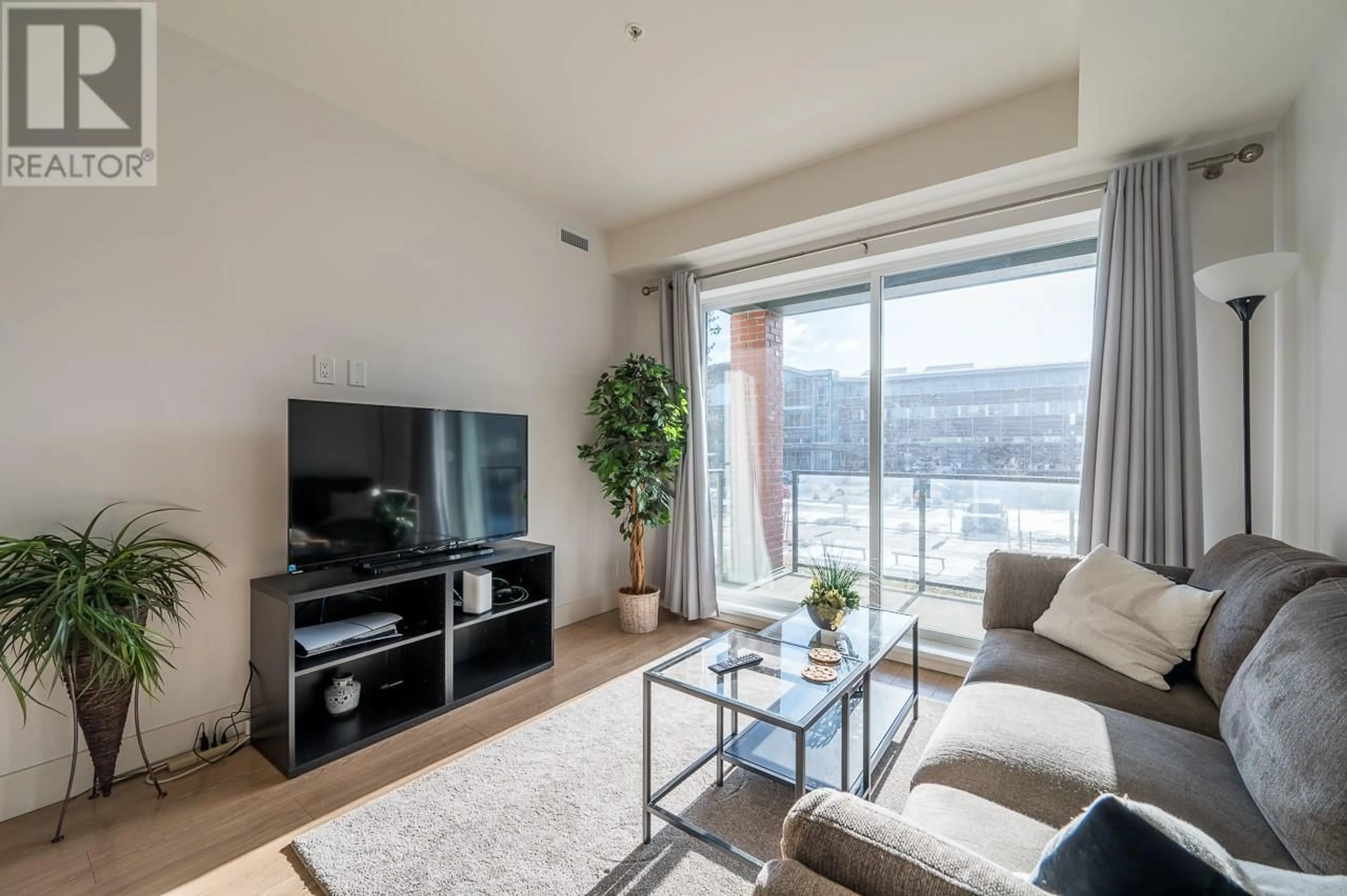 Living room with furniture, wood/laminate floor for 885 University Drive Unit# 209, Kamloops British Columbia V2C0K2