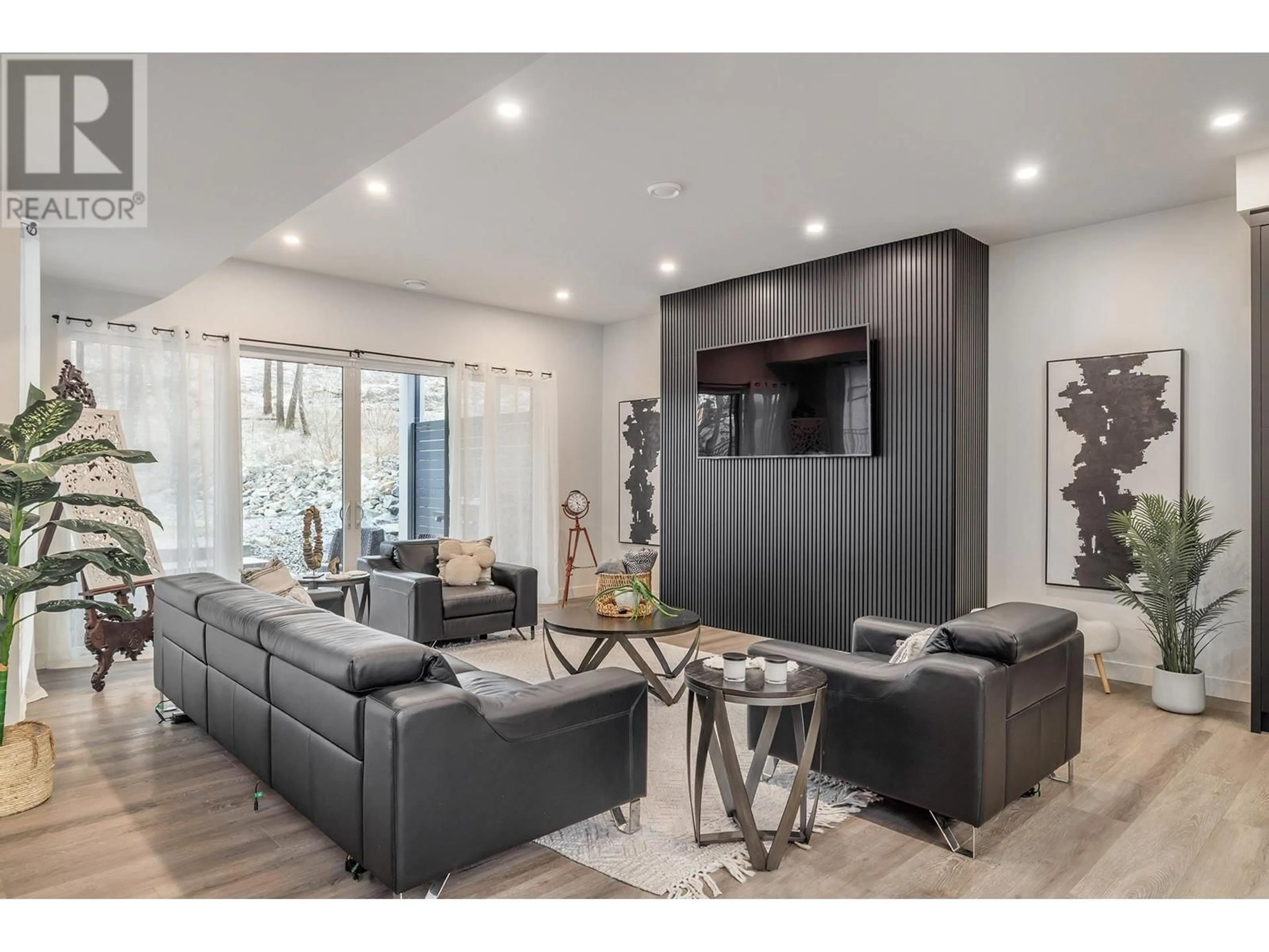 Living room with furniture, wood/laminate floor for 10235 Beacon Hill Drive, Lake Country British Columbia V4V0A9