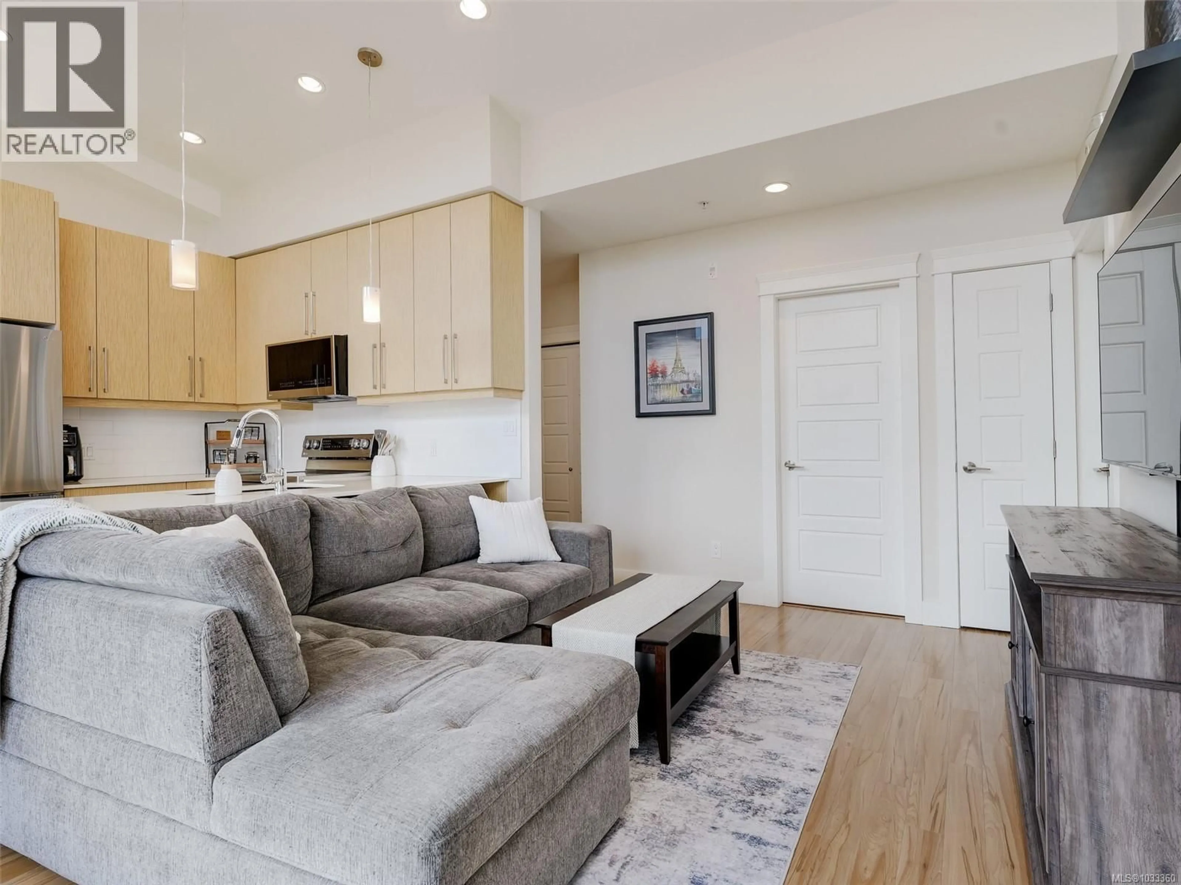 Living room with furniture, wood/laminate floor for 401 - 7161 WEST SAANICH ROAD, Central Saanich British Columbia V8M1P7