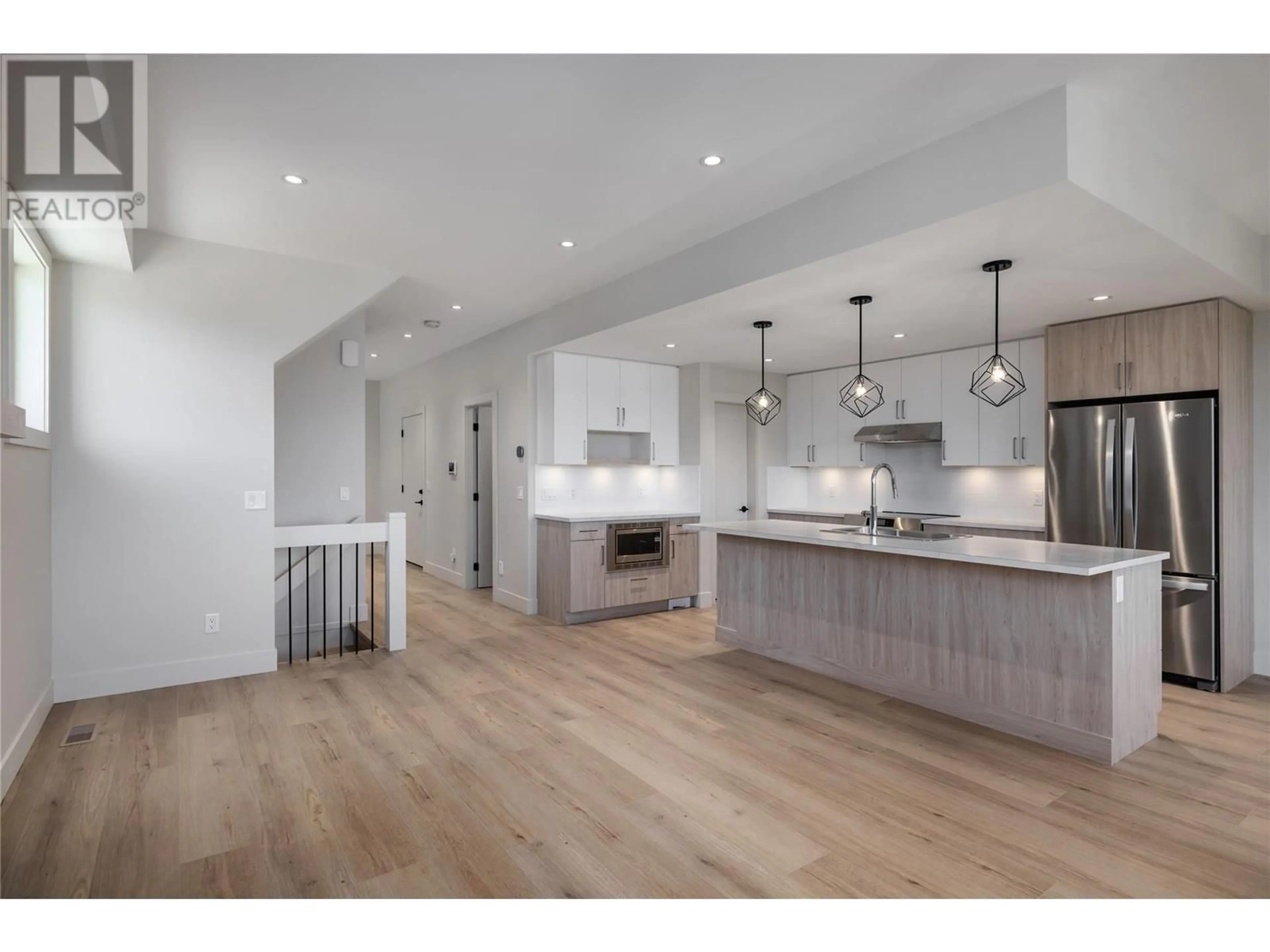 Open concept kitchen, wood/laminate floor for 896 Dehart Road, Kelowna British Columbia V1W4N2