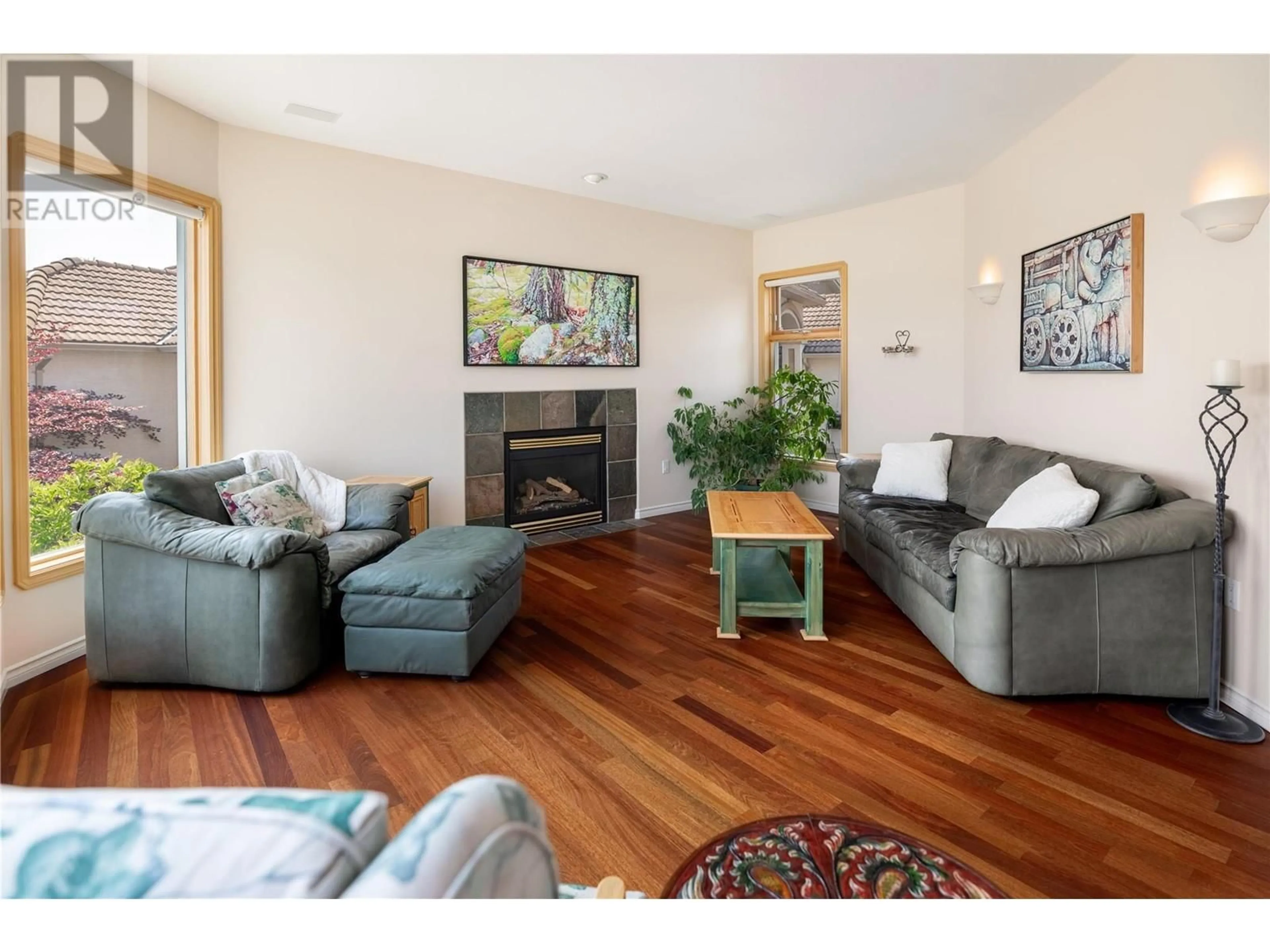 Living room with furniture, wood/laminate floor for 3076 Quail Crescent, Kelowna British Columbia V1V2A1