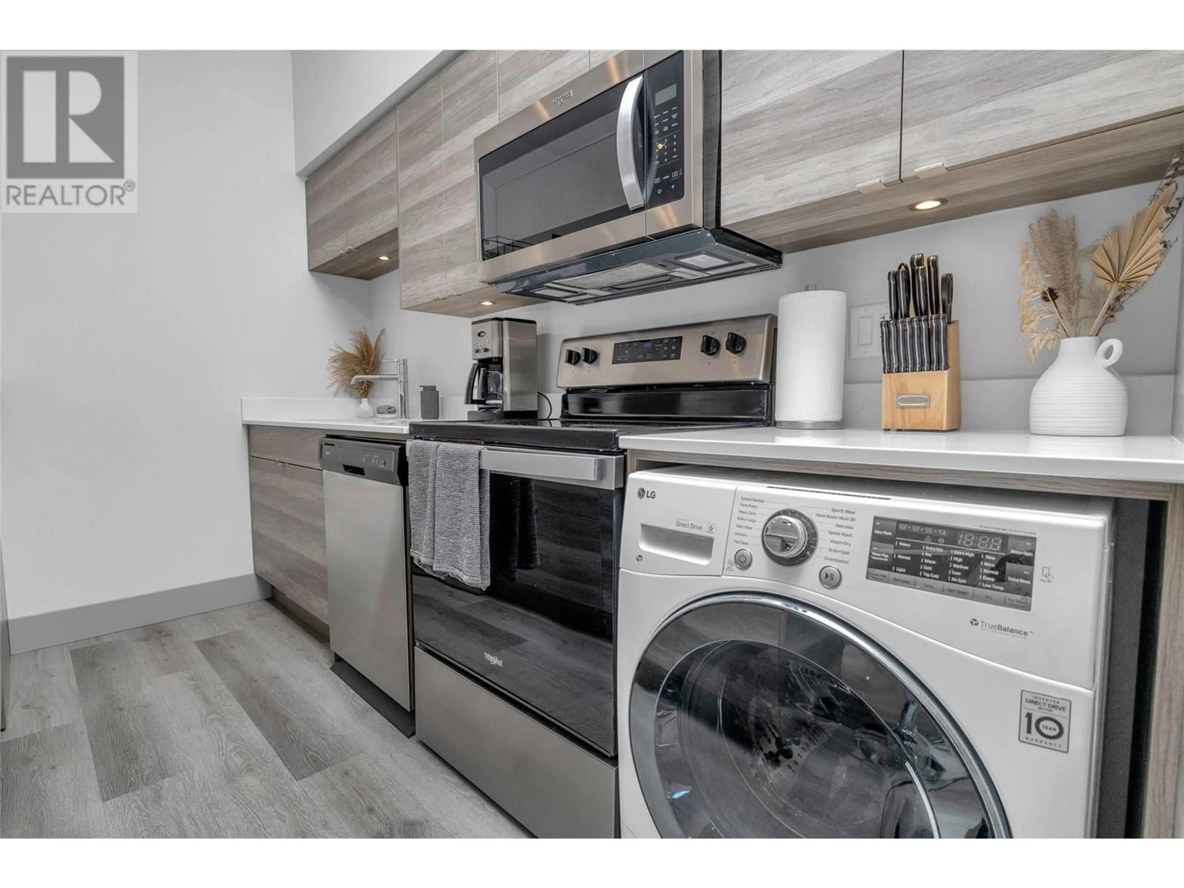 Kitchen with laundary machines, wood/laminate floor for 211 - 2555 LAKESHORE ROAD, Vernon British Columbia V1H0A4