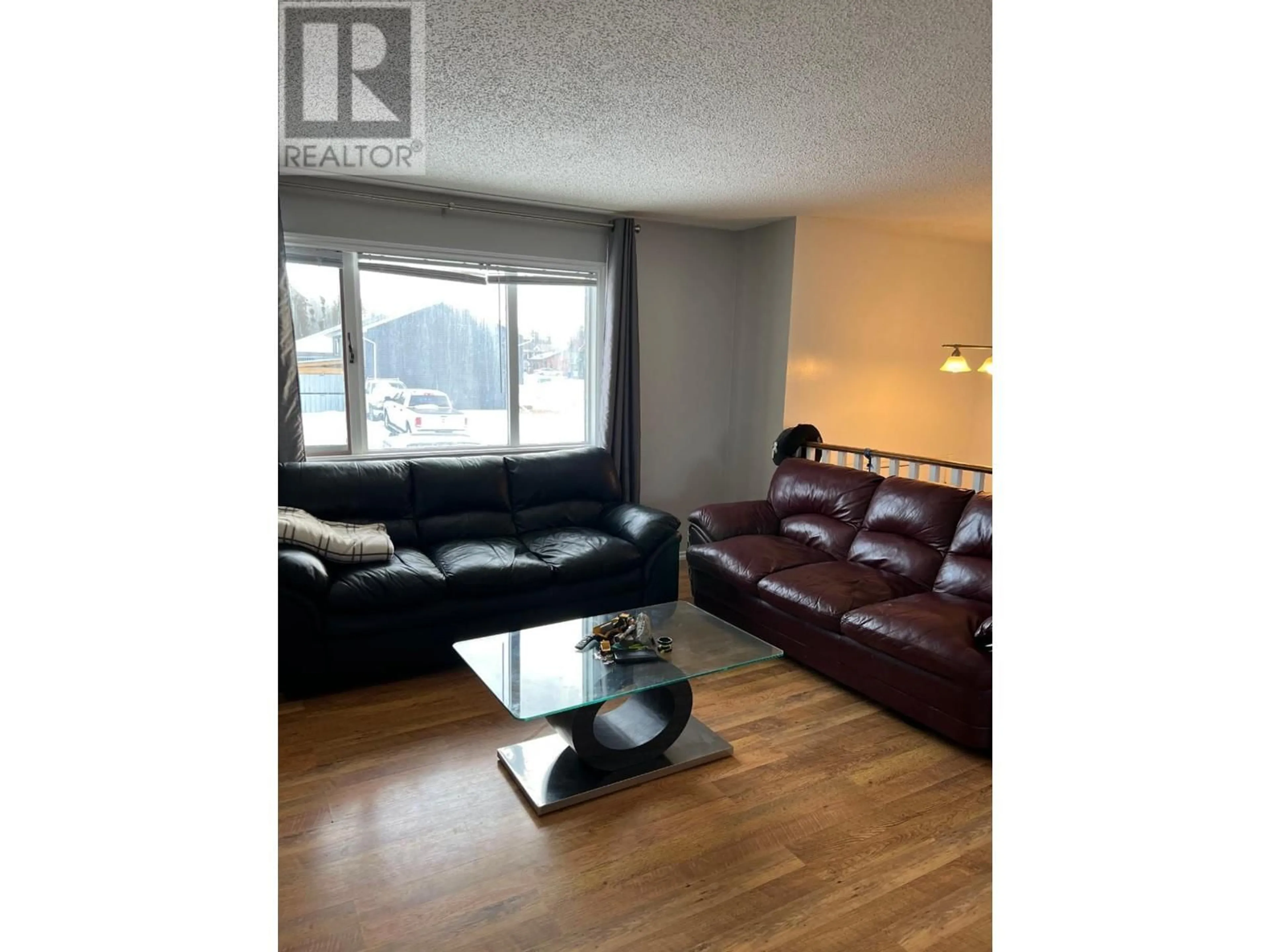 Living room with furniture, wood/laminate floor for 104 BULLMOOSE CRESCENT, Tumbler Ridge British Columbia V0C2W0