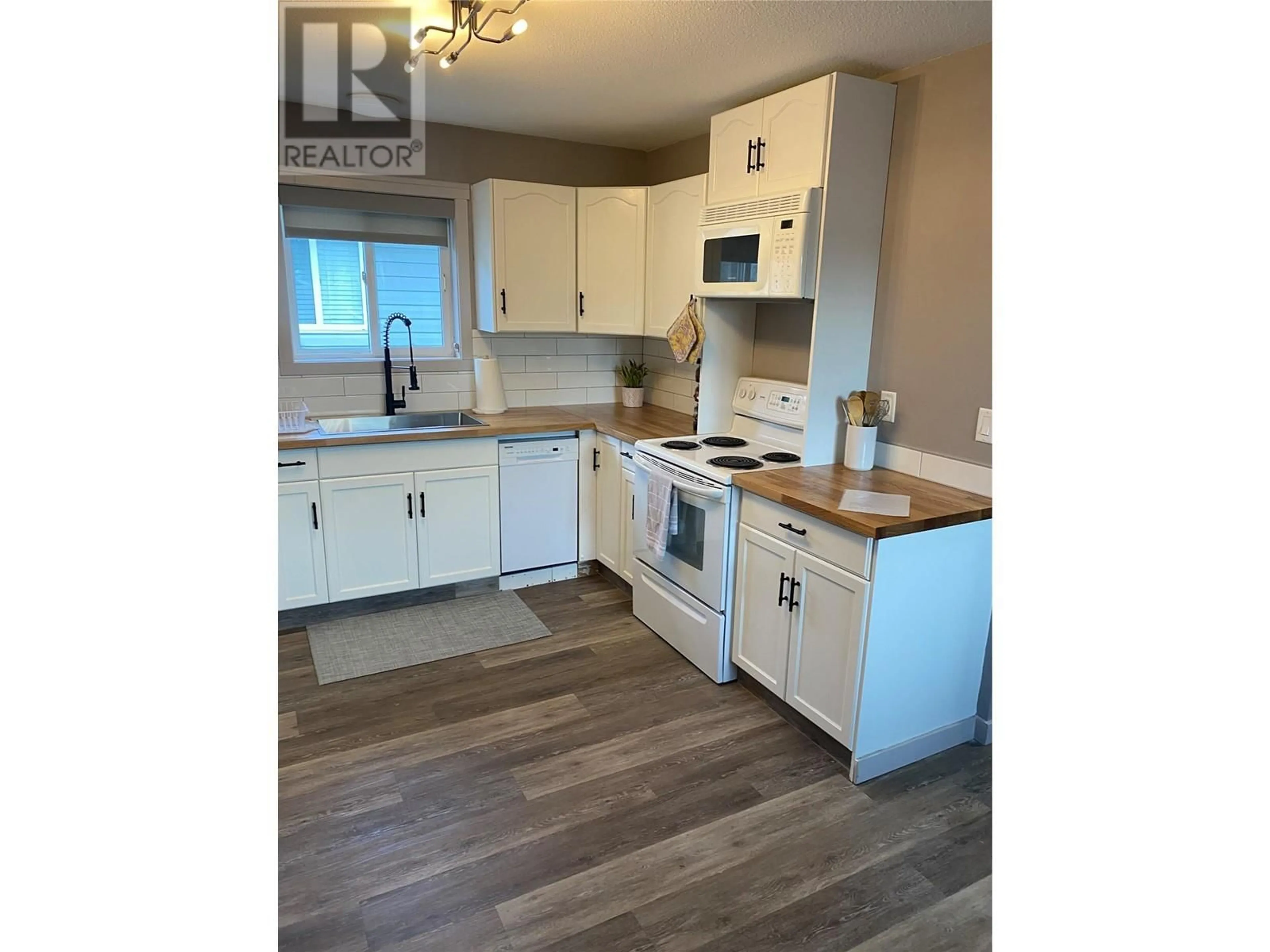 Open concept kitchen, wood/laminate floor for 476 TENNIS Street, Penticton British Columbia V2A5R3