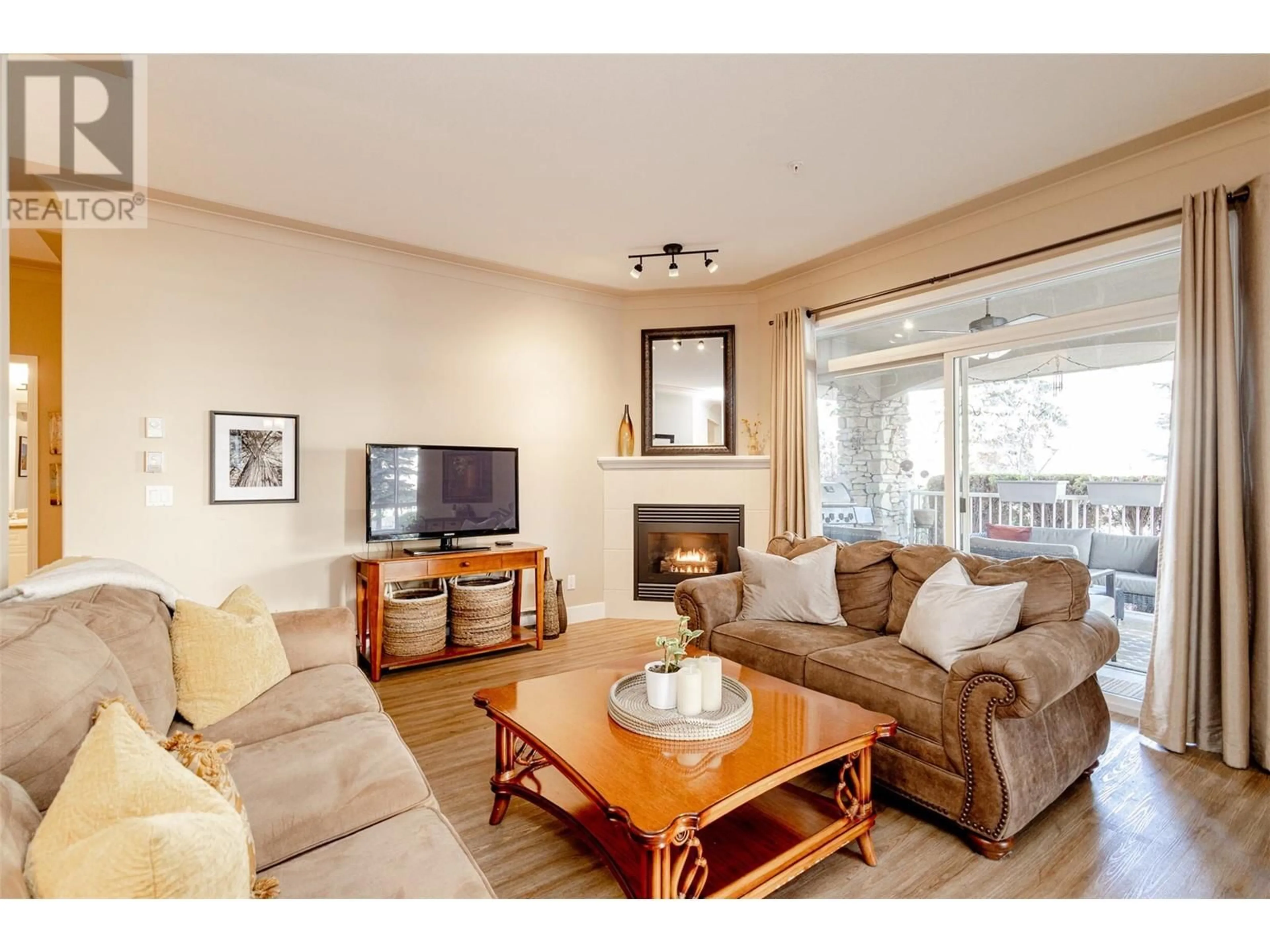 Living room with furniture, wood/laminate floor for 1966 Enterprise Way Unit# 111, Kelowna British Columbia V1Y3S8