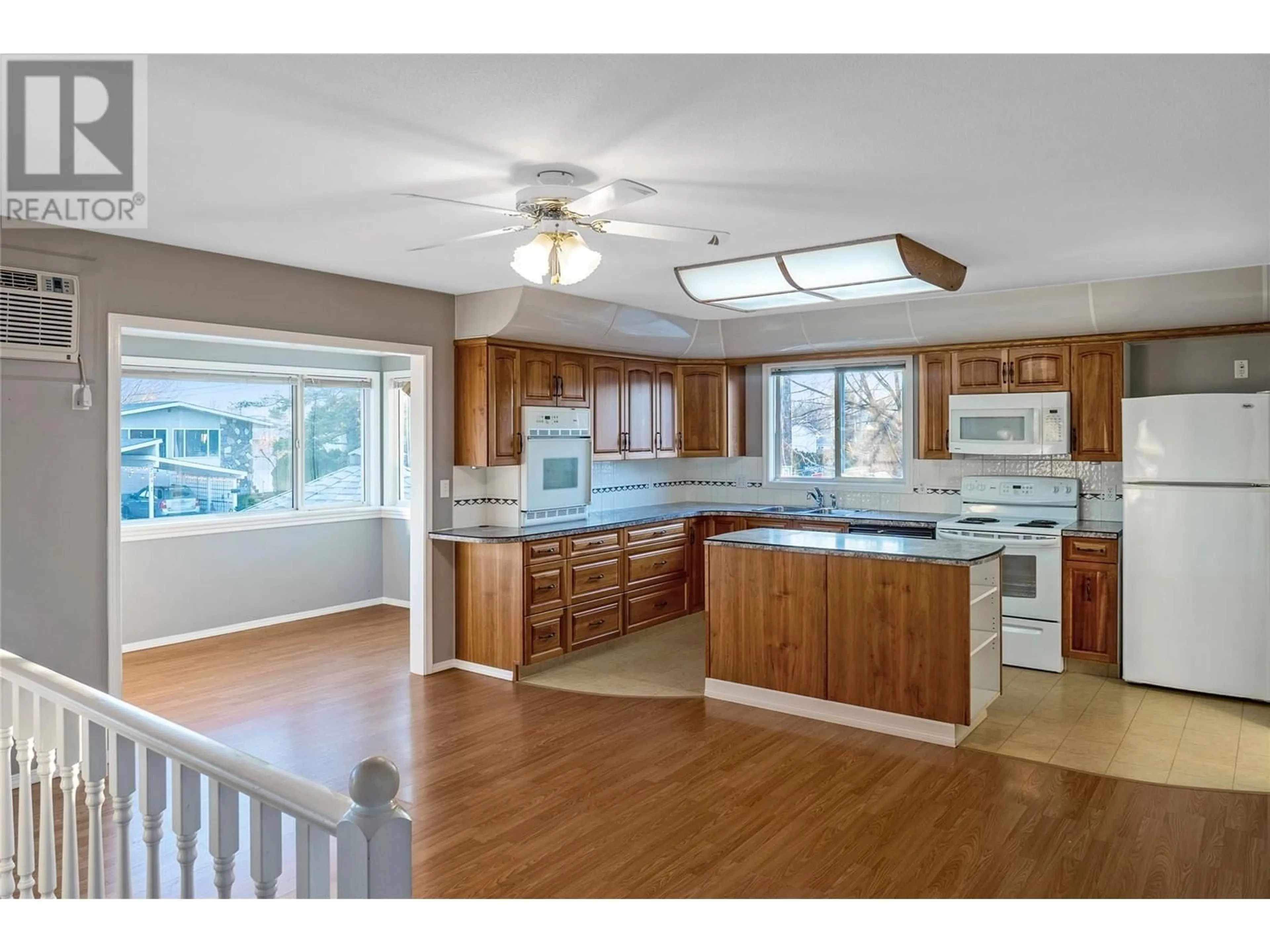 Open concept kitchen, wood/laminate floor for 790 Swordy Road, Kelowna British Columbia V1W3Y8