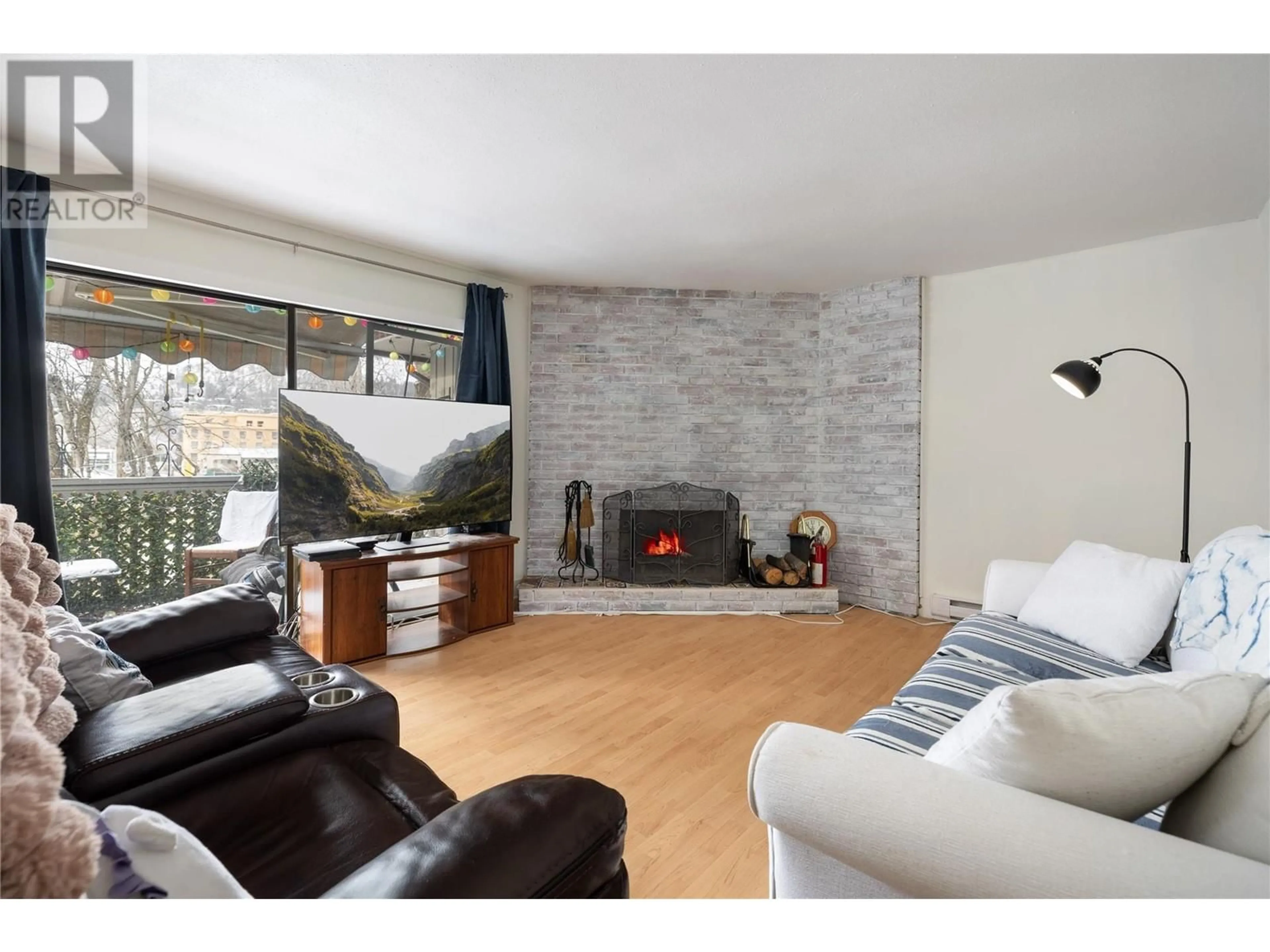 Living room with furniture, wood/laminate floor for 8 - 340 MILLS ROAD, Kelowna British Columbia V1X4G8