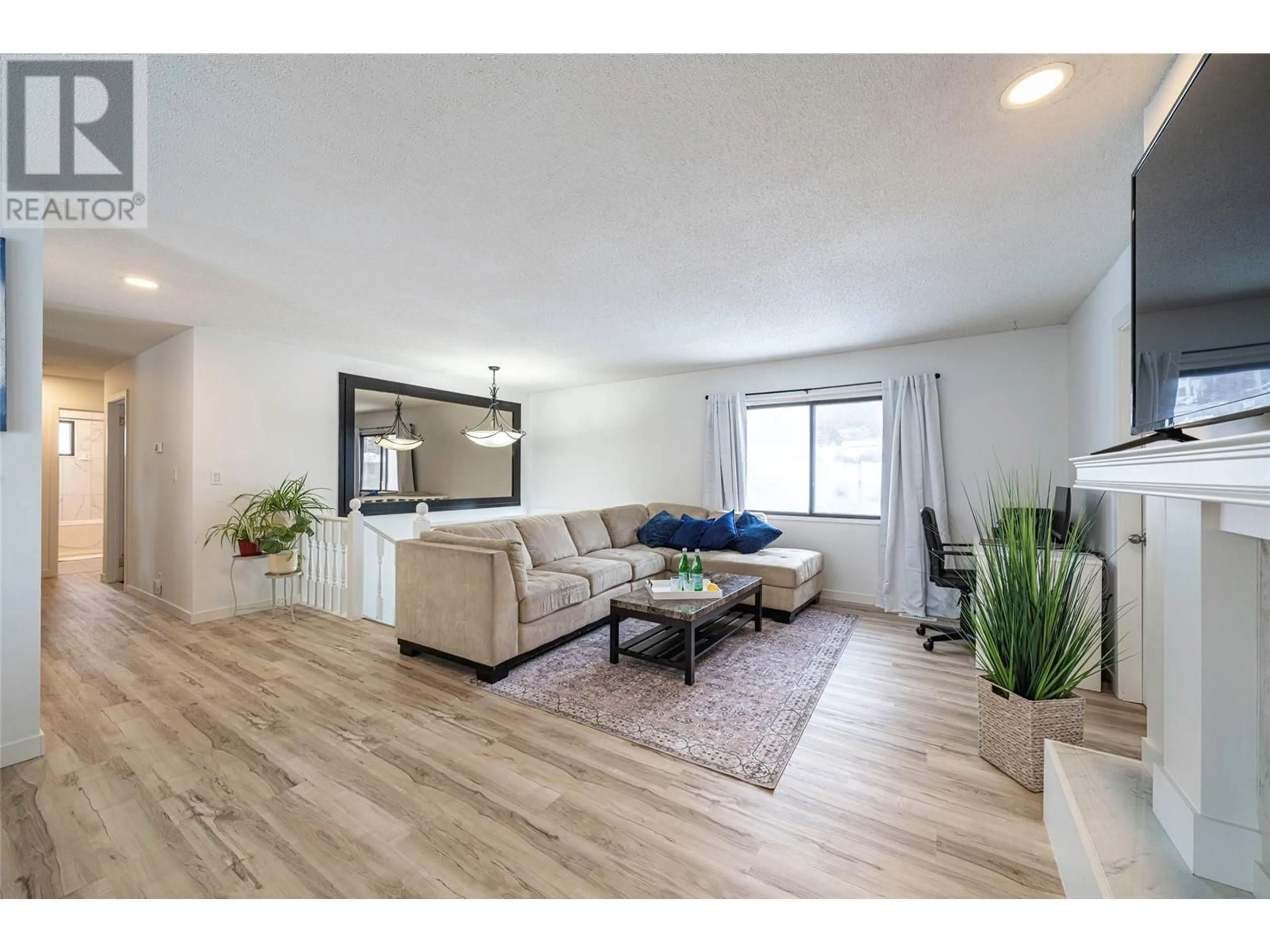 Living room with furniture, wood/laminate floor for 2412 Butt Road, West Kelowna British Columbia V4T1N7