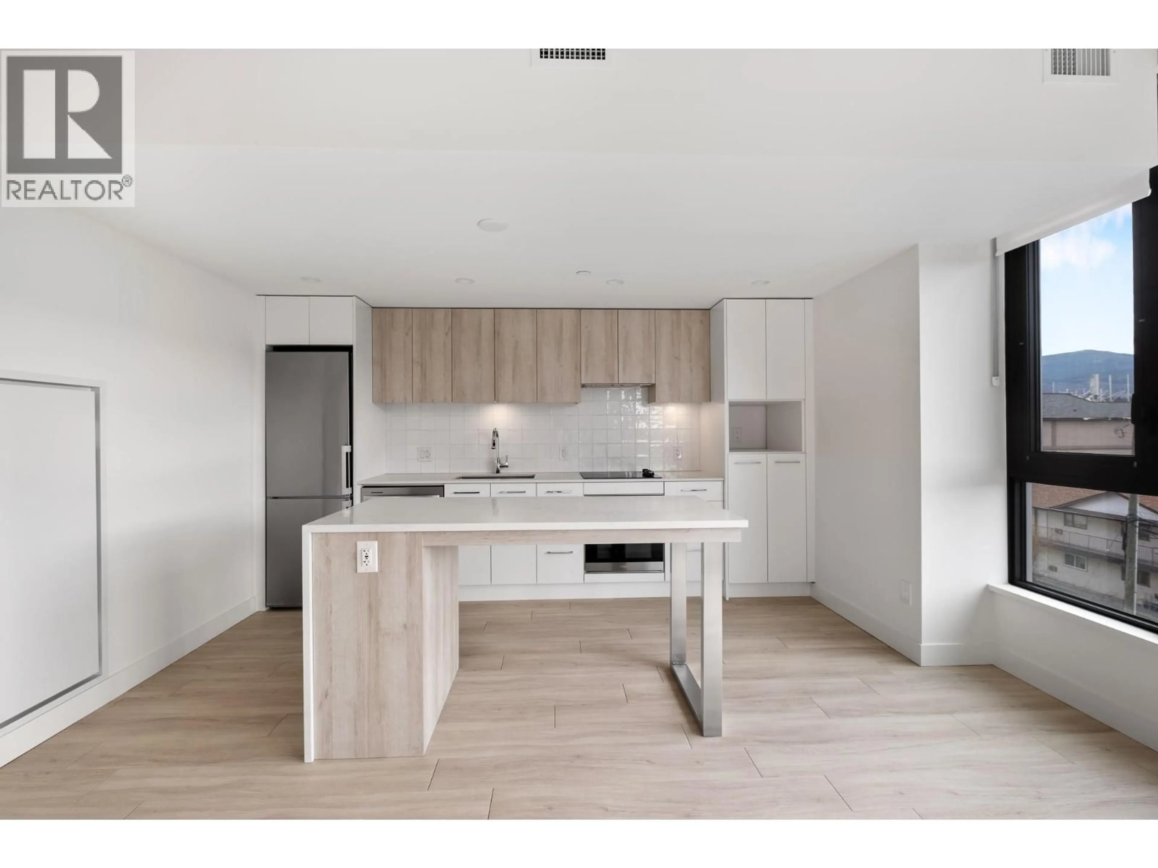 Open concept kitchen, wood/laminate floor for 401 - 3699 CAPOZZI ROAD, Kelowna British Columbia V1W0G3
